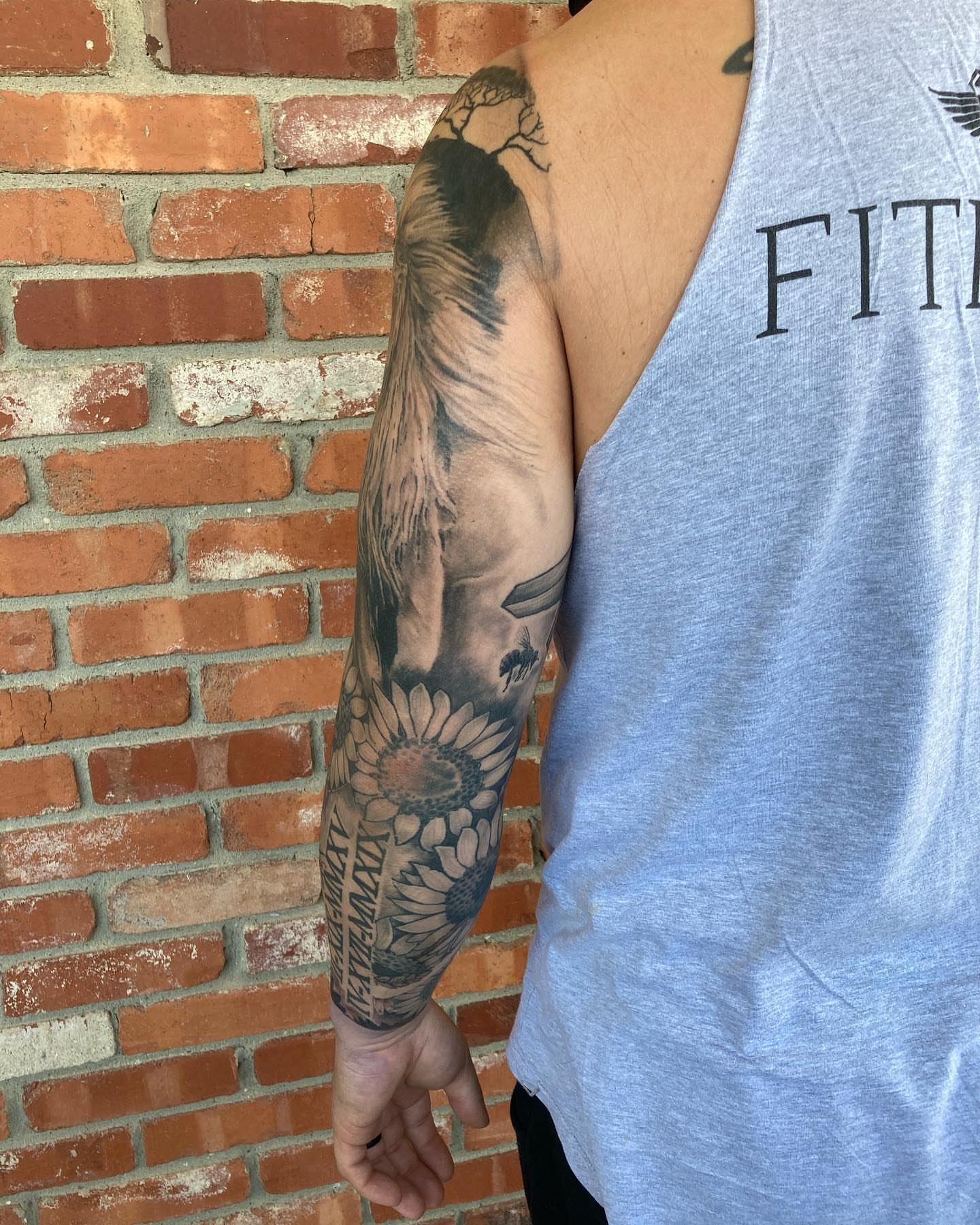 Sunflower and bird realism tattoo on the forearm by Chuck House