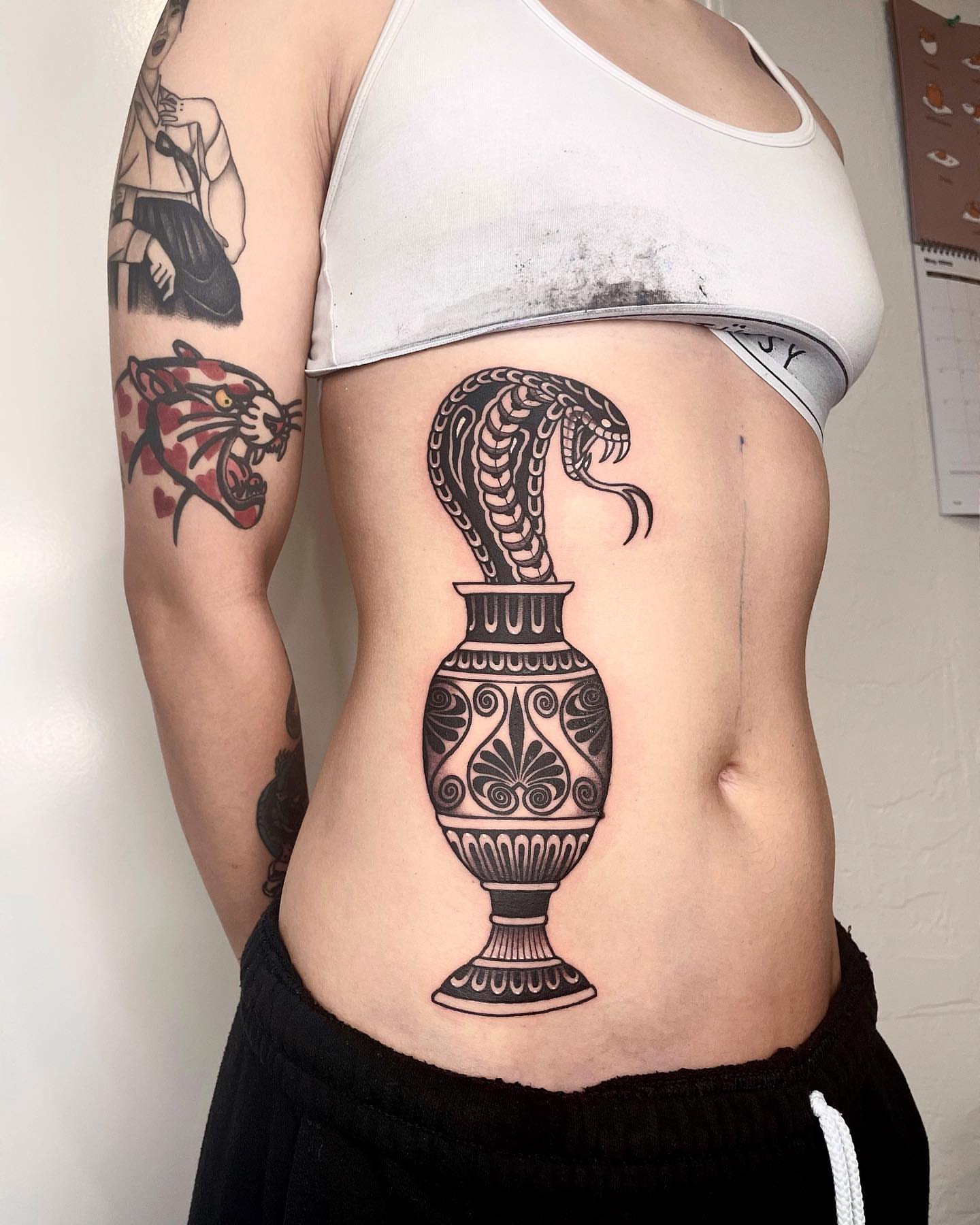 Serpent and urn black and grey tattoo on the ribs by LA tattoo