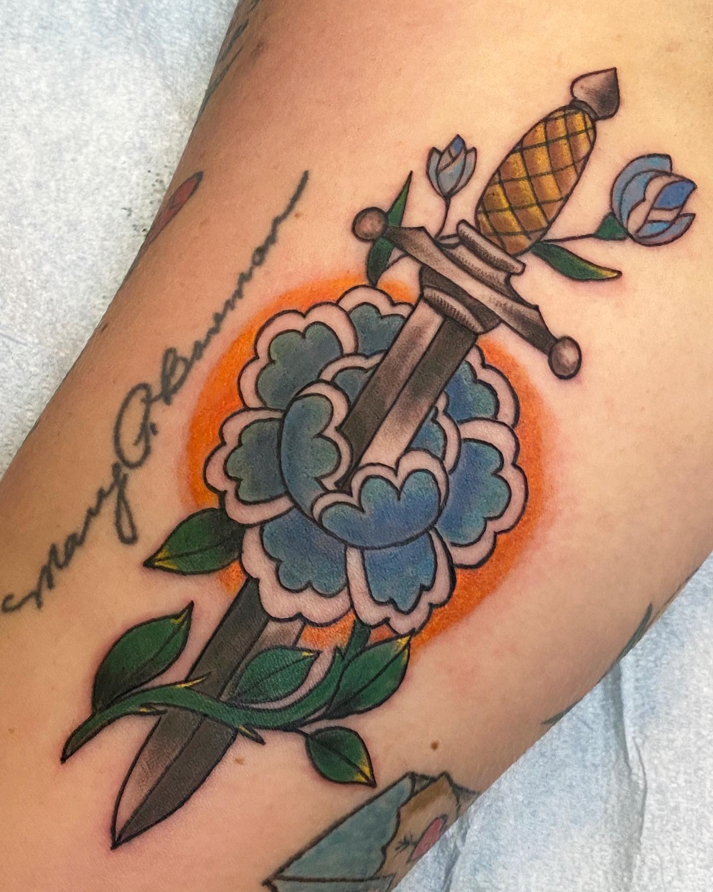 Dagger and flower American traditional tattoo on the forearm by Sally Darling