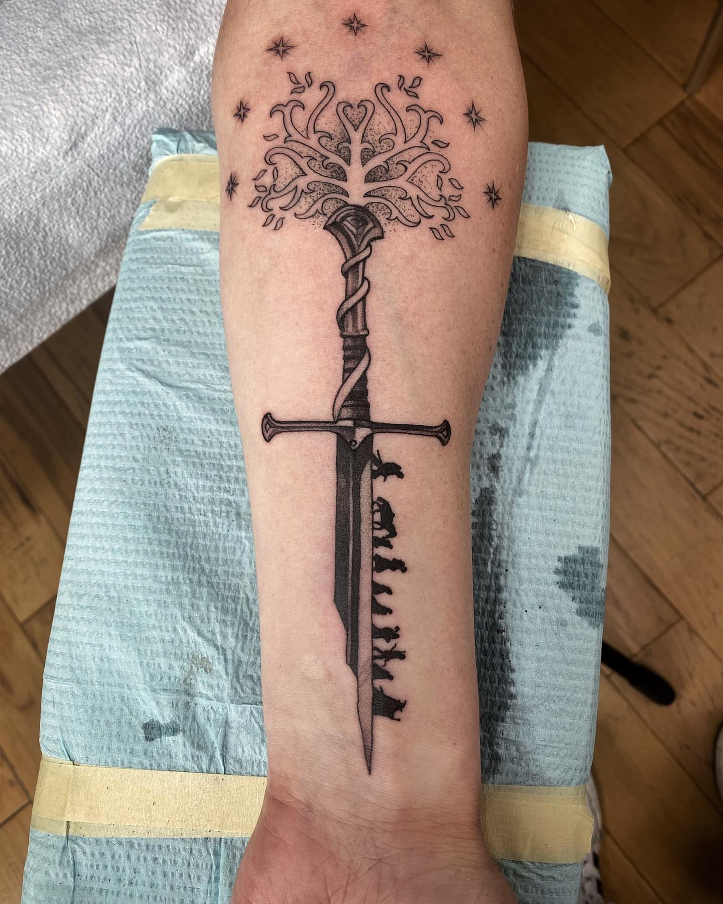 Sword and tree black and grey tattoo on the forearm by David Gray