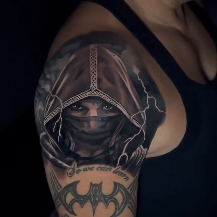 Woman in a hood realism tattoo by Travis Chick