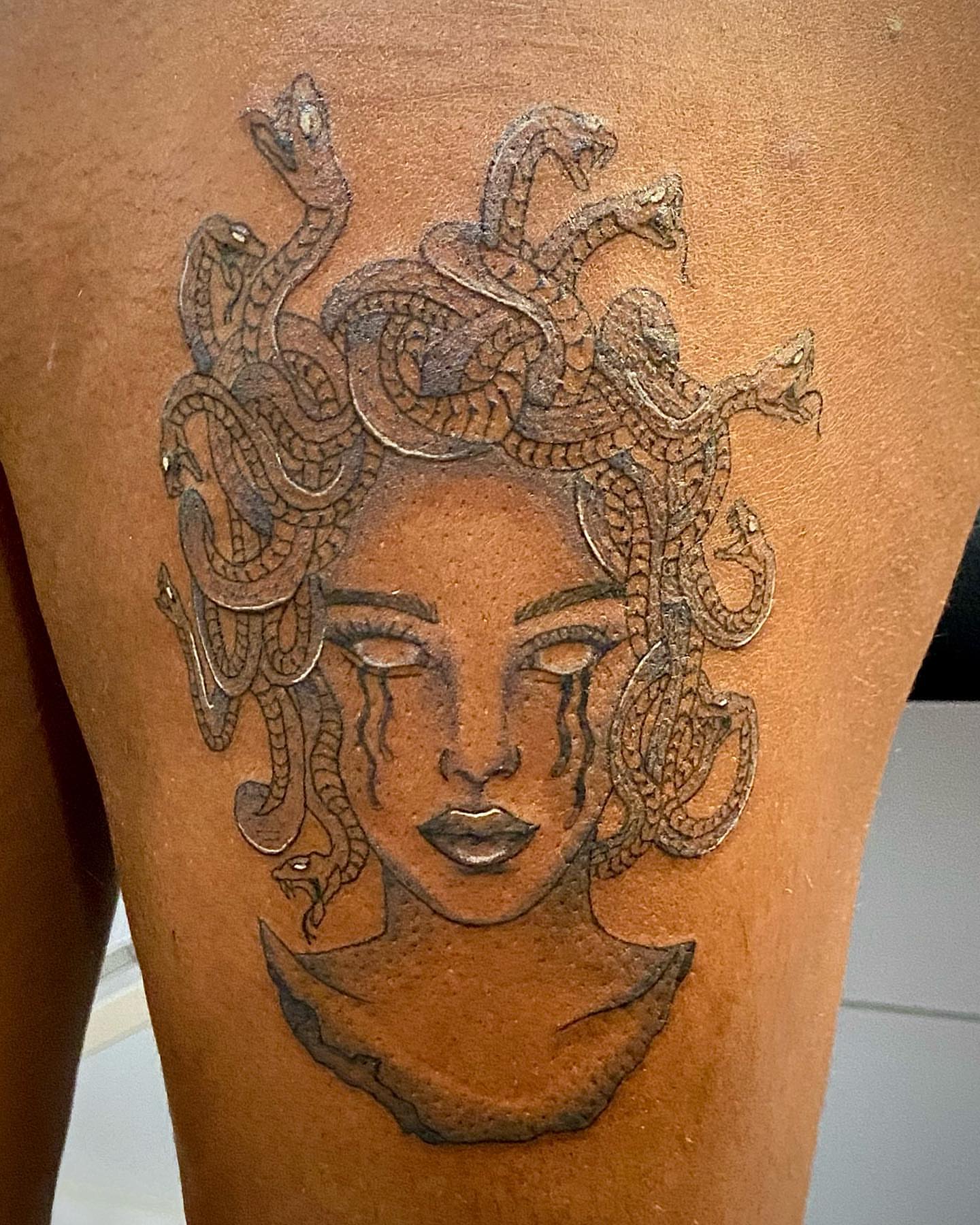 Medusa black and grey tattoo on the thigh by Erika Nambo