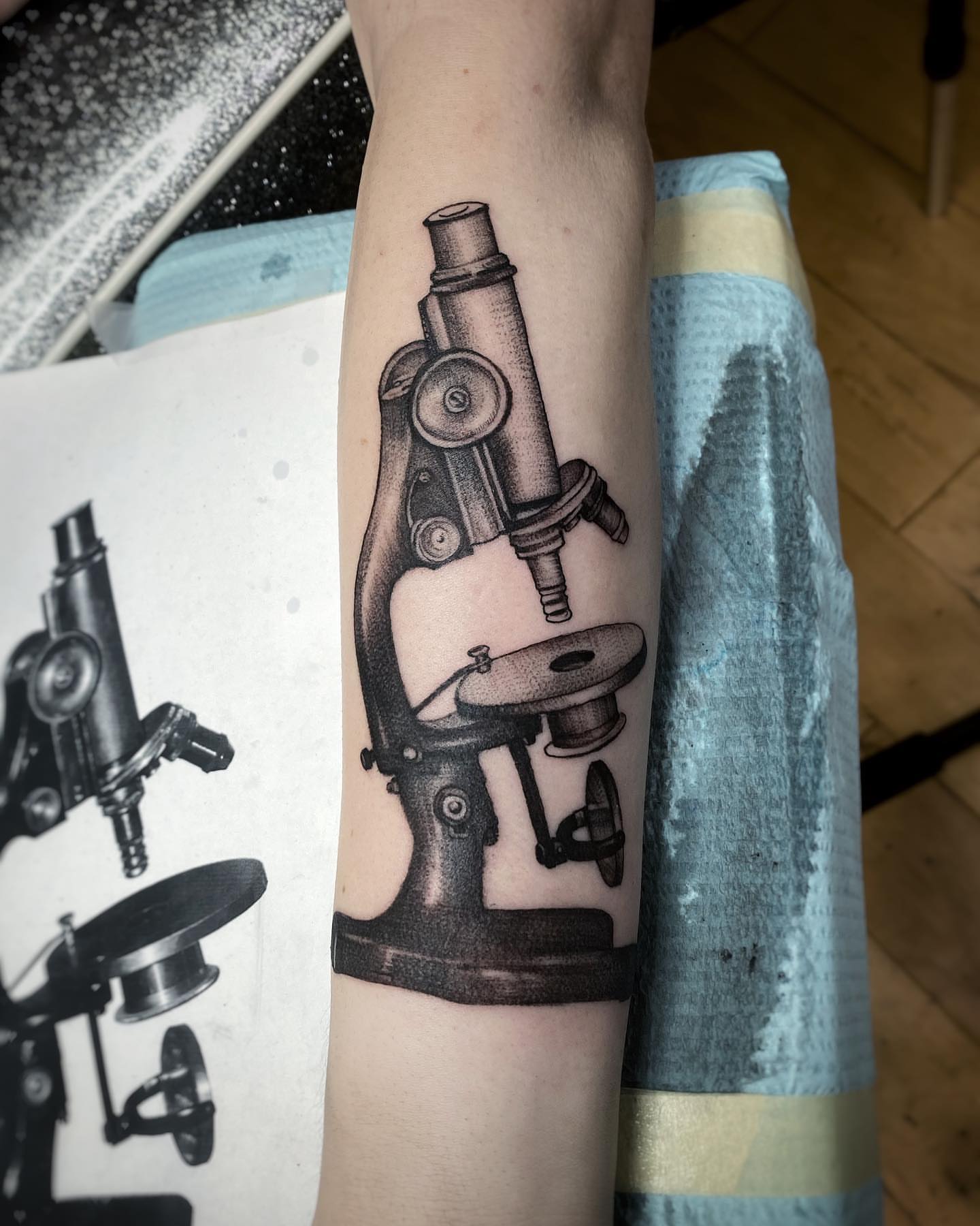 Microscope black and grey tattoo on the forearm by David Gray