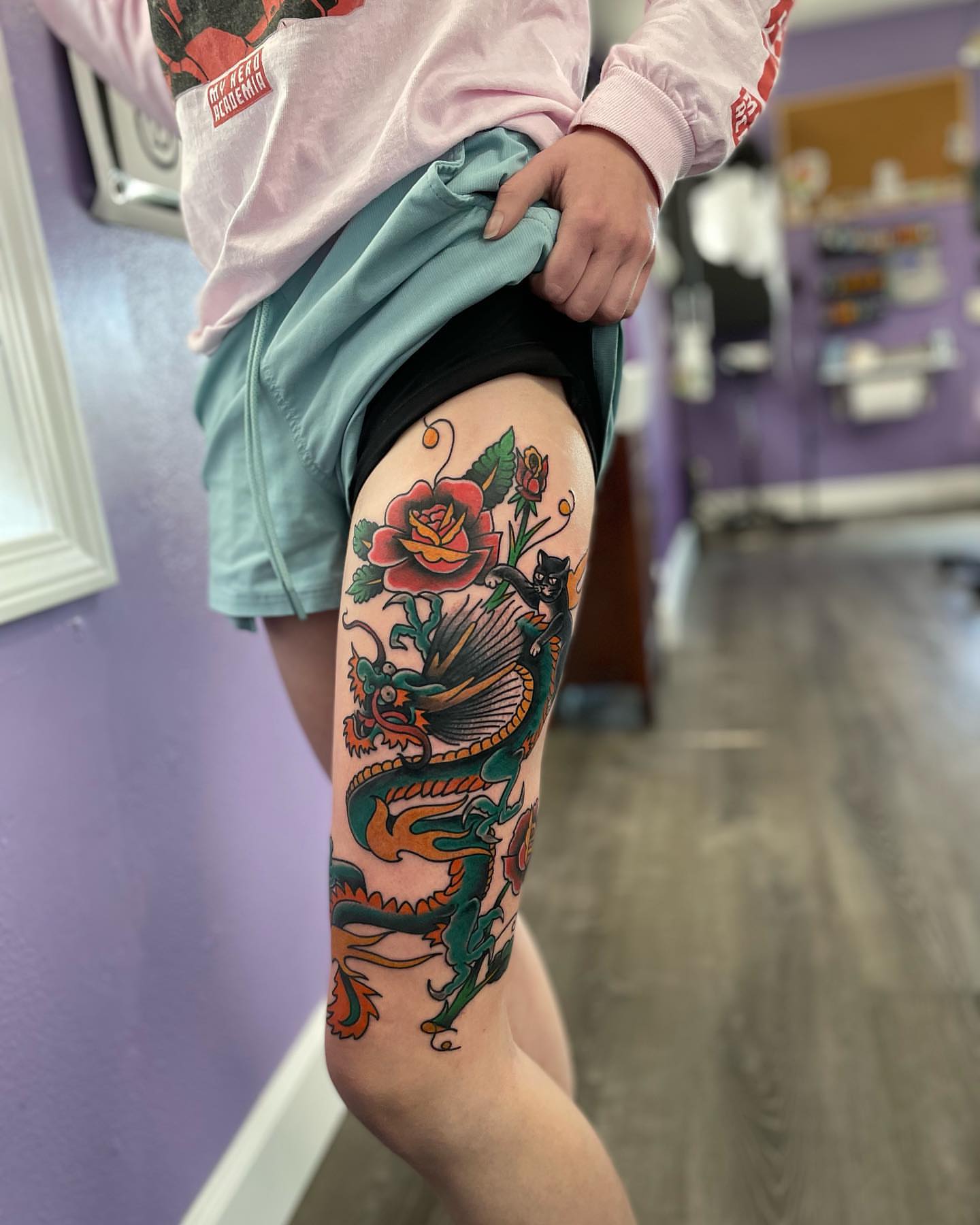Dragon and flowers American traditional tattoo on the thigh by Don Robison