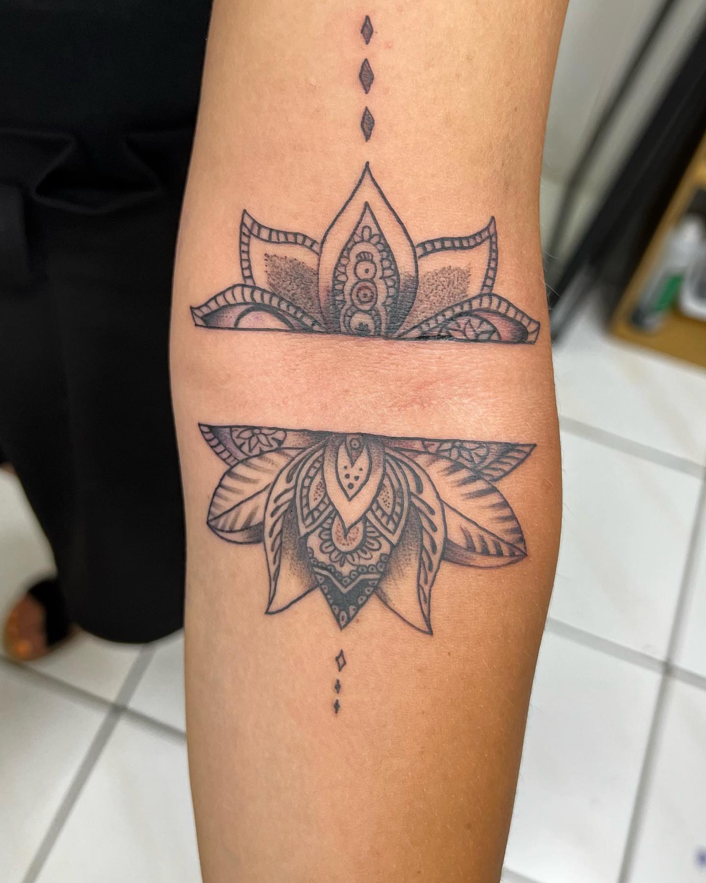 Lotus flower dotwork tattoo on the forearm by oxideTattoo, Morne-à-l'Eau