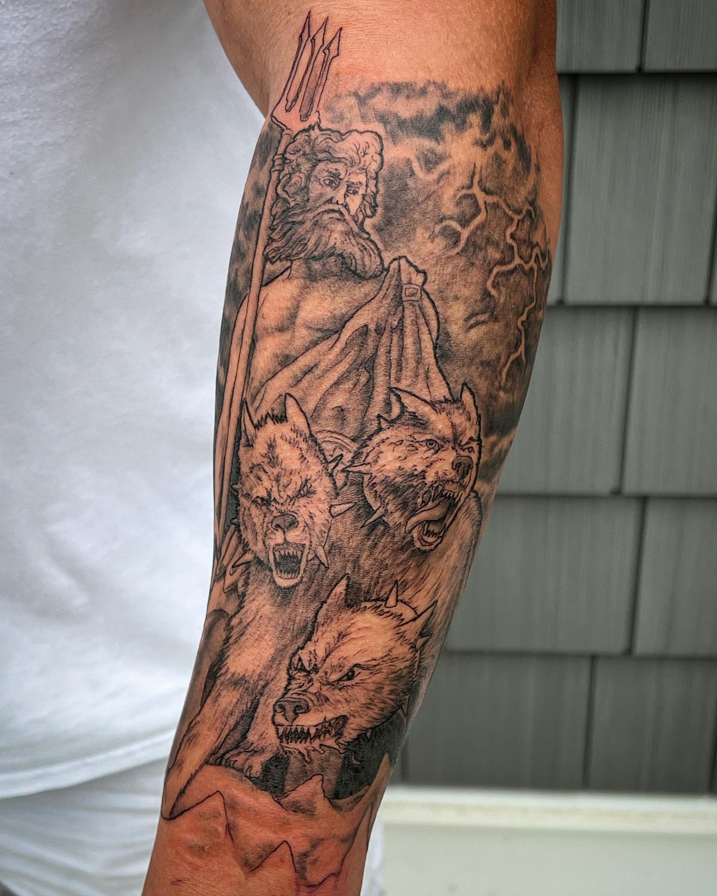 Poseidon with wolves black and grey tattoo on the forearm by Iconic Ink, Millbury, Massachusetts