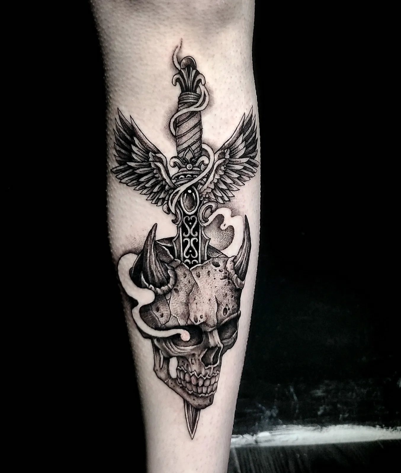 Sword through skull dark realism tattoo on the forearm by Sydney Paige, Mentor, Ohio