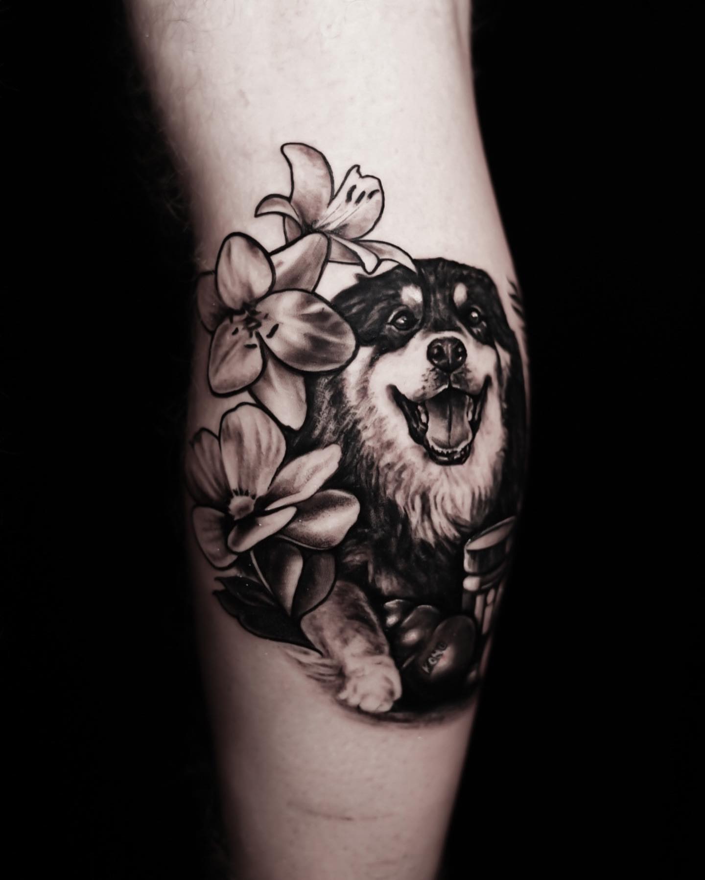 Dog with flowers realism tattoo on the forearm by David Gordon