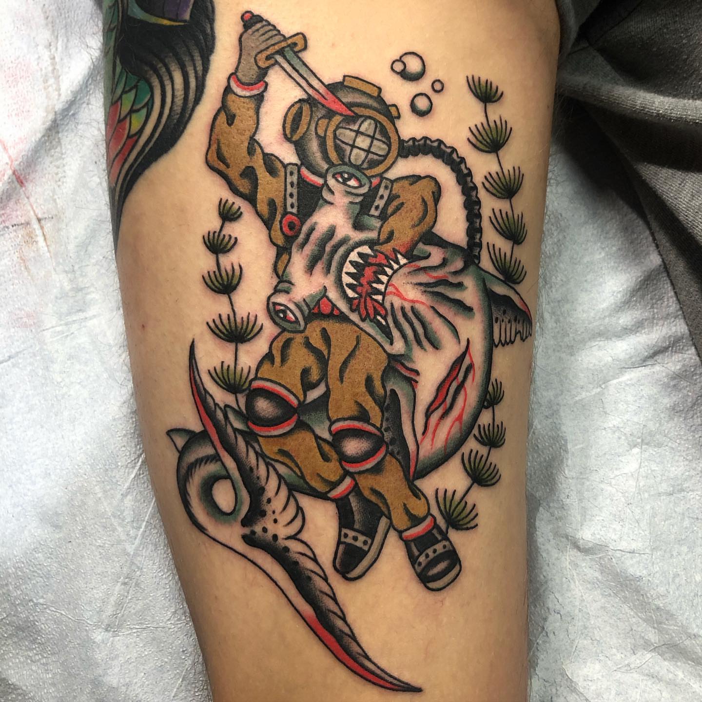 Diver riding dinosaur American traditional tattoo on the leg by Sean McMahon