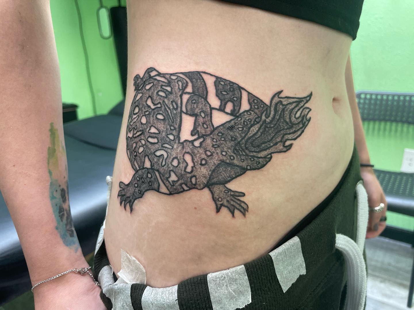 Lizard black and grey tattoo on the ribs by Al