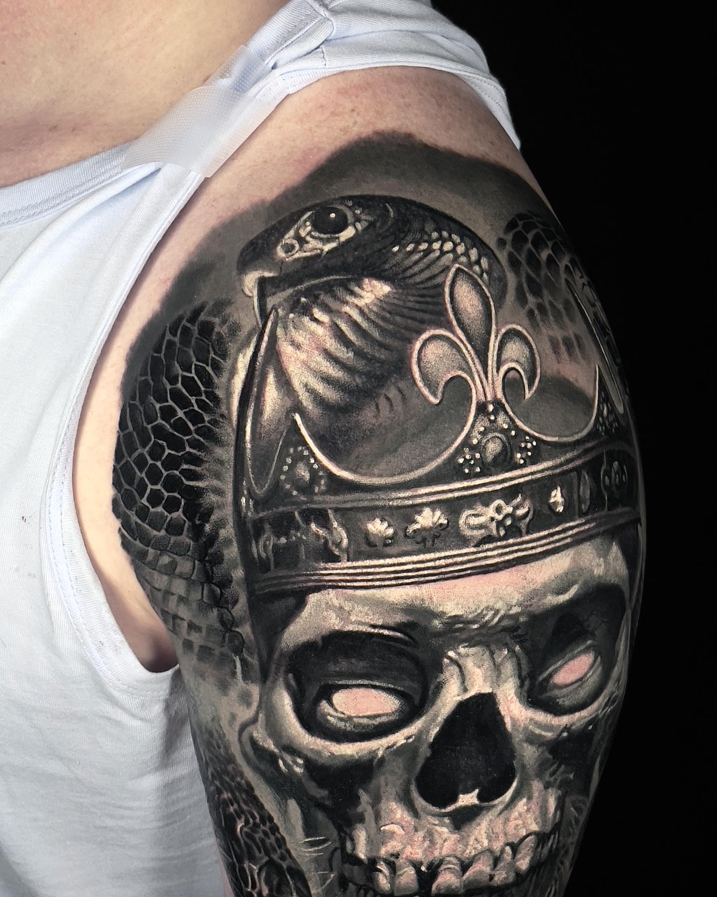 Skull with bird and fleur-de-lis realism tattoo on the shoulder by Robert Morton, Cleveland, Ohio