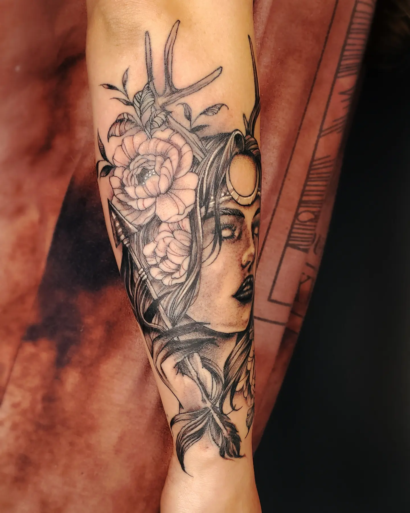 Woman with flowers realism tattoo on the forearm by Neil Ohmie