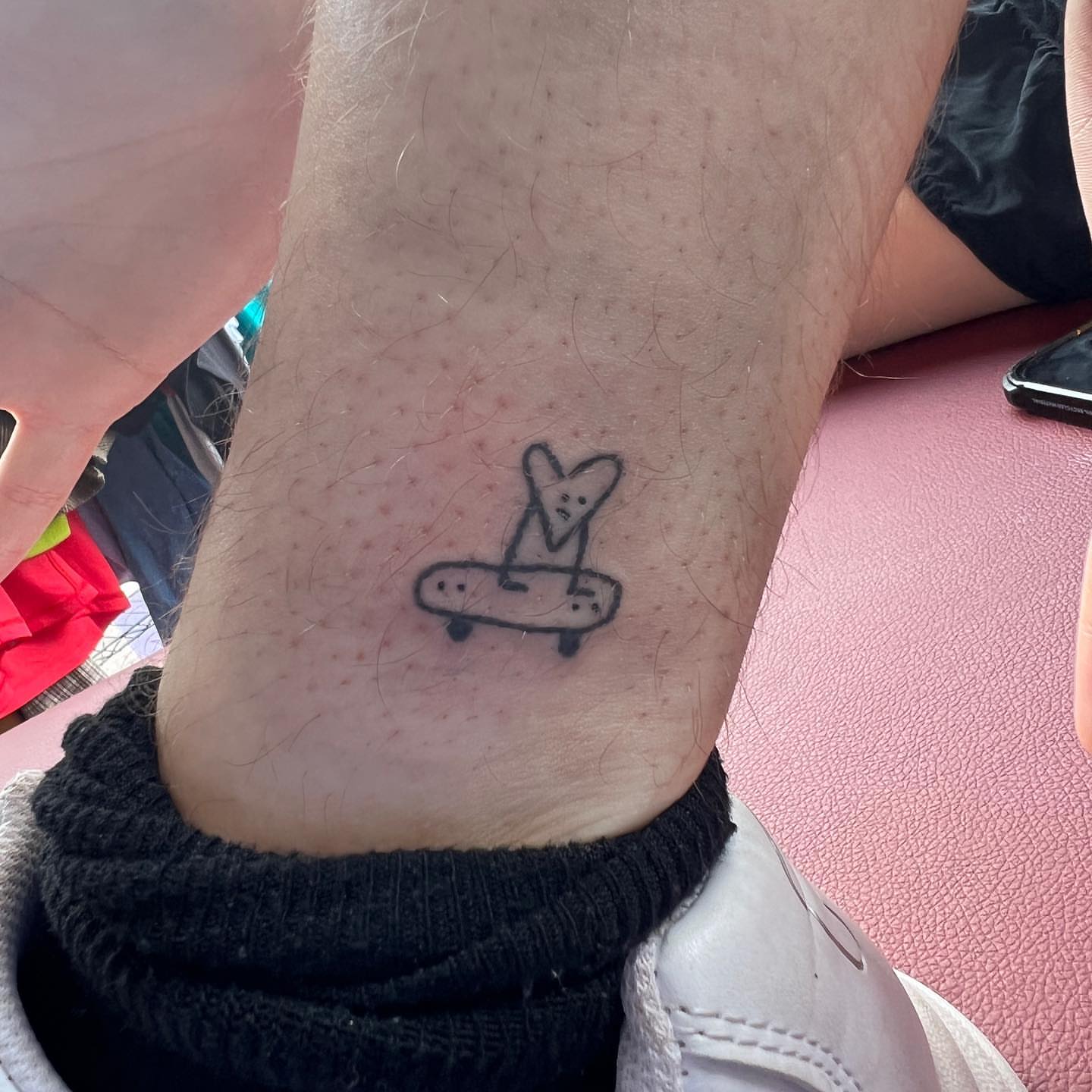 Skateboard with heart minimalist tattoo on the forearm by mars