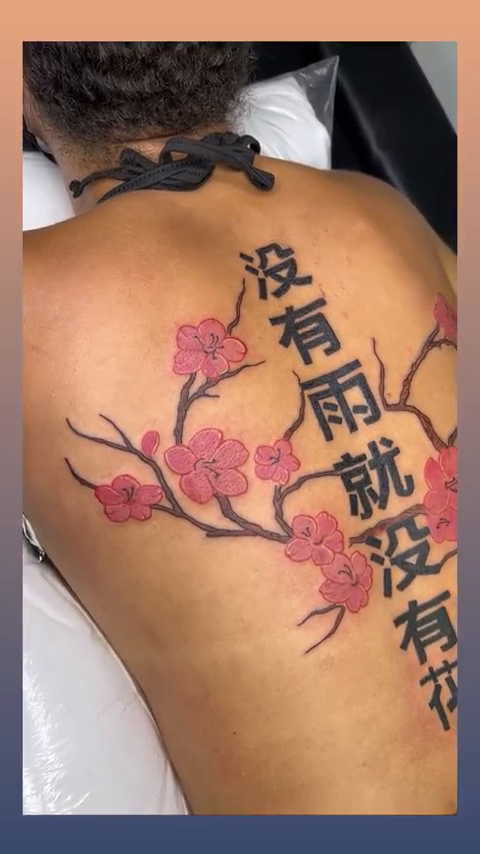 Cherry blossoms with Japanese text watercolor tattoo on the back by Jazz Walker