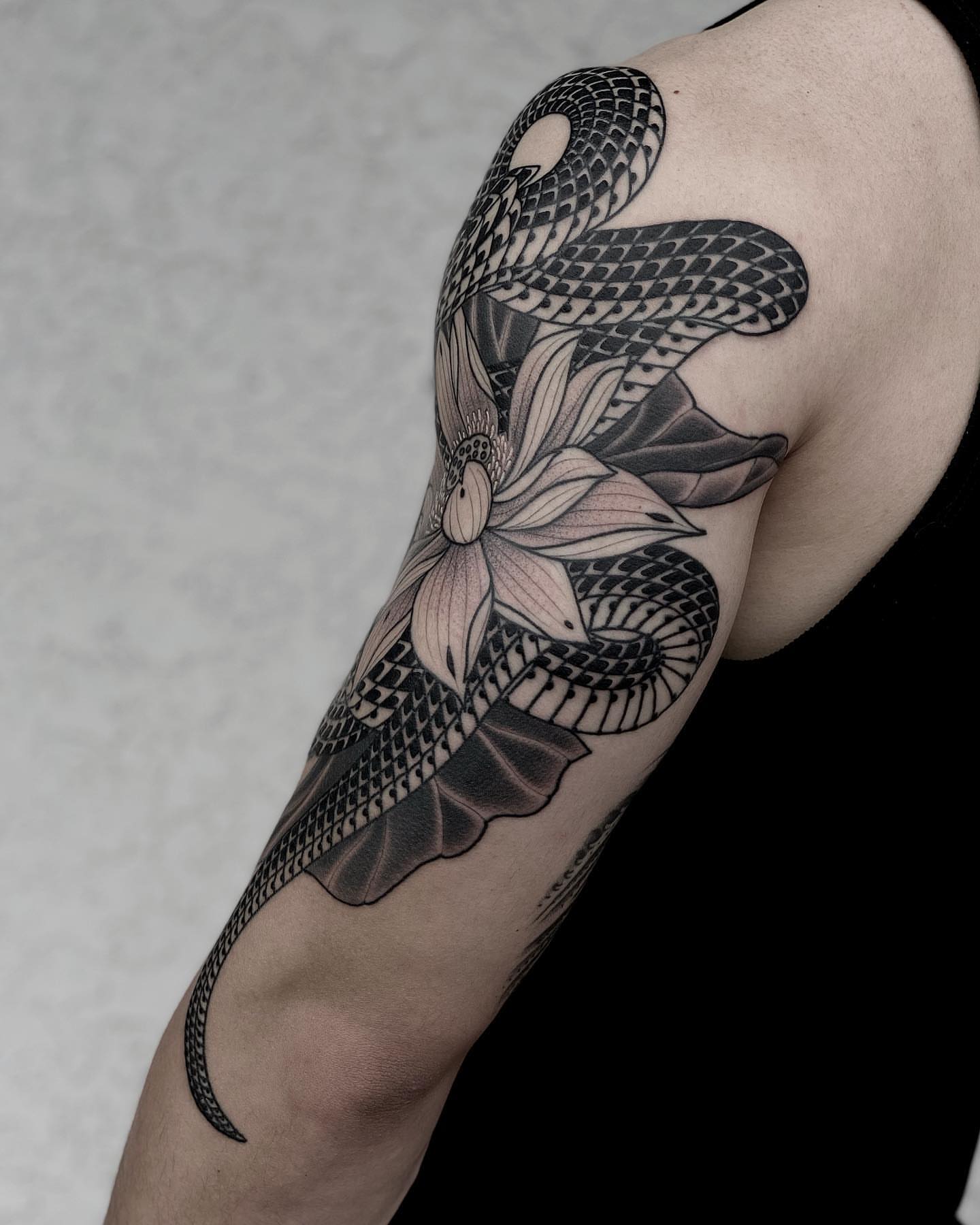 Snake and lotus realism tattoo on the forearm by Tyler Charles
