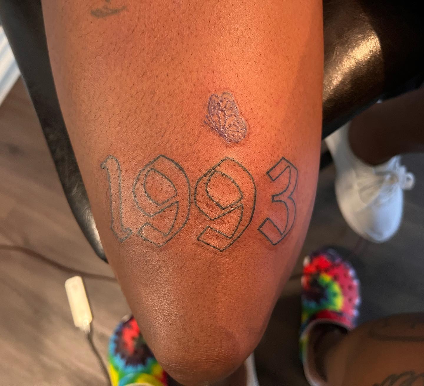 Year 1993 lettering script tattoo on the thigh by Lea-yae’