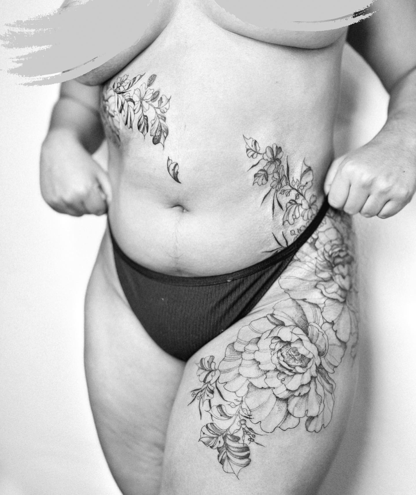 Floral black and grey tattoo on the thigh by Ayauna Mai