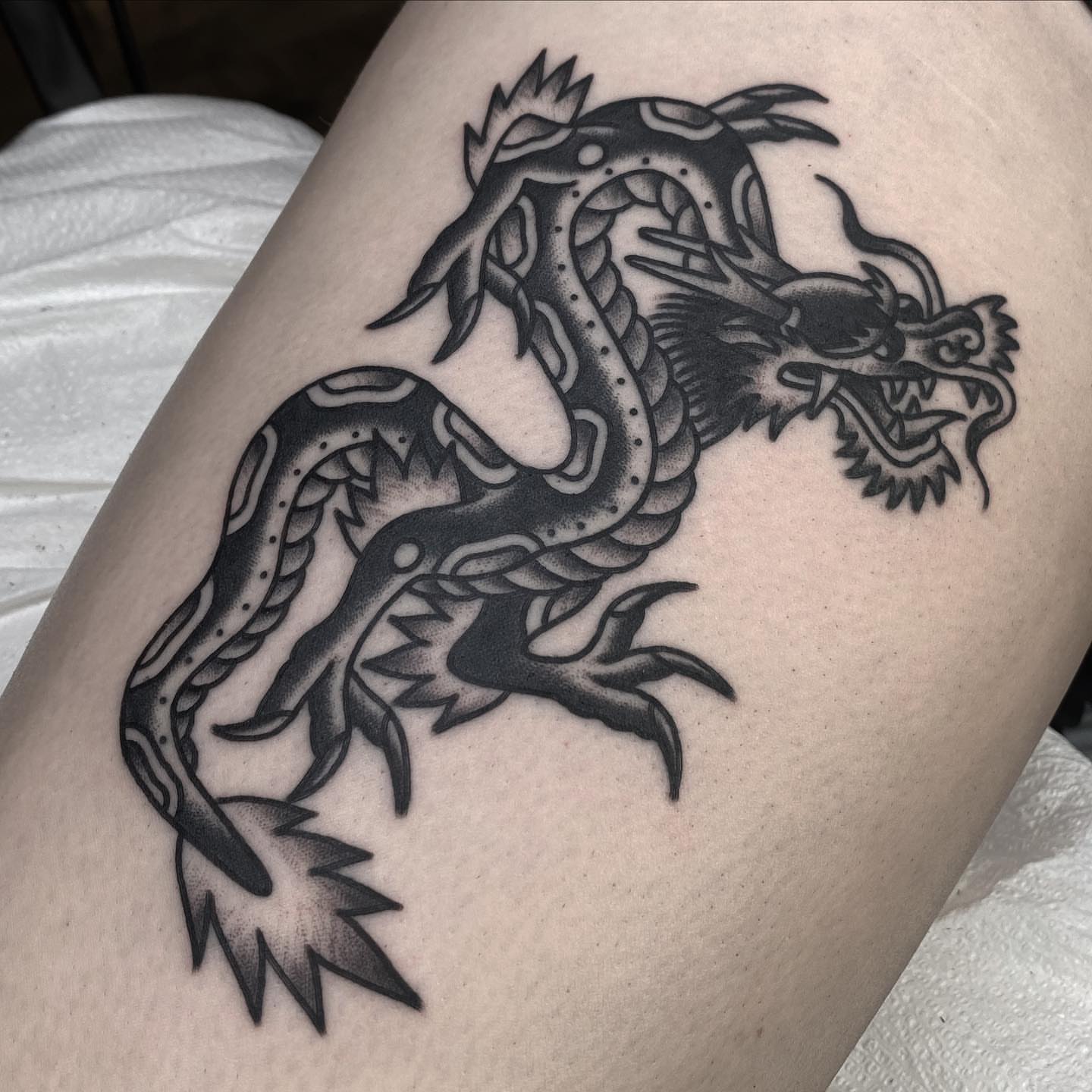 Dragon black and grey tattoo on the thigh by andrewtattoos
