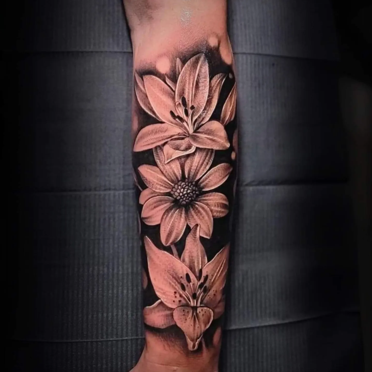 Lilies realism tattoo on the forearm by Mark Melanson