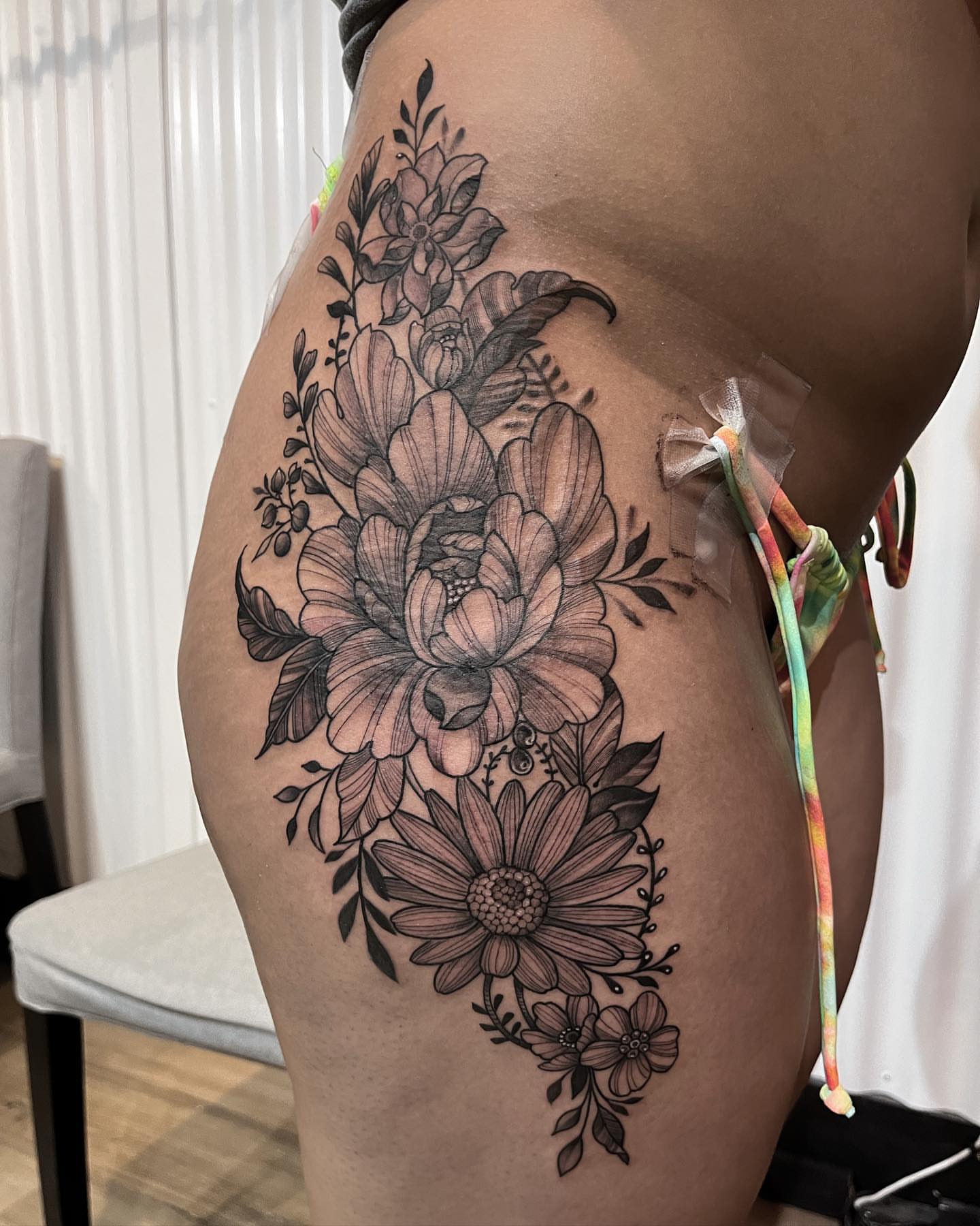 Floral bouquet black and grey tattoo on the thigh by Neri Gersaint