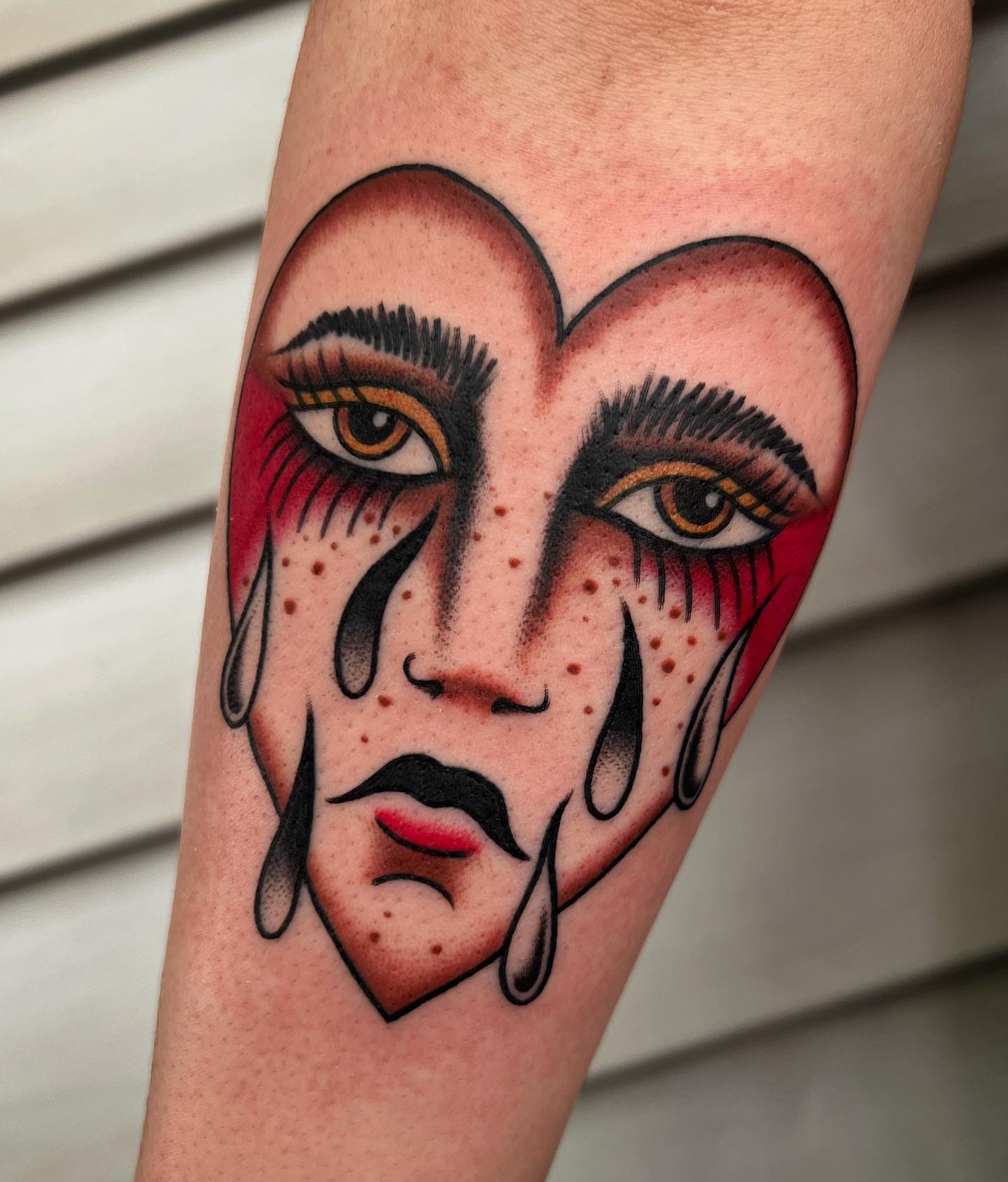 Tearful face American traditional tattoo on the forearm by Daniel Mesen