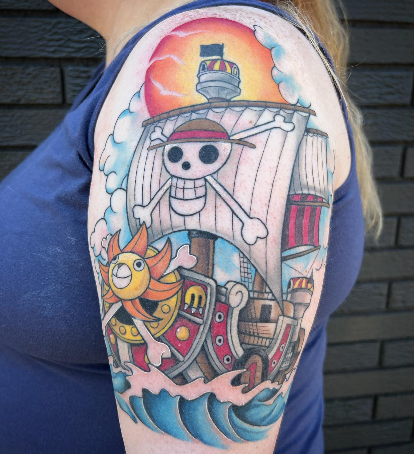 Pirate ship and skeleton new school tattoo on the upper arm by Blu