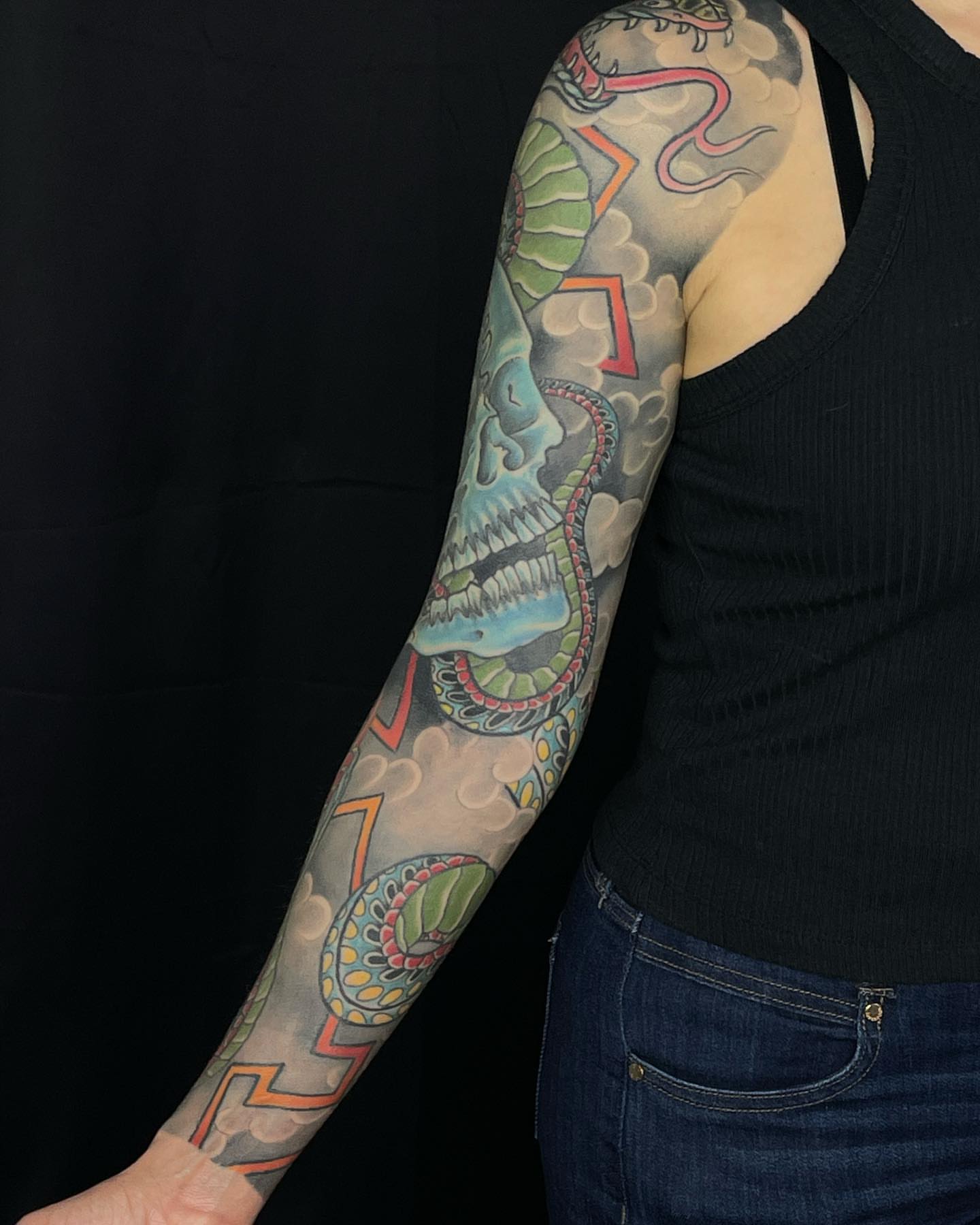 Skull and snake American traditional tattoo on the upper arm by Mark Thompson, Dallas, Texas