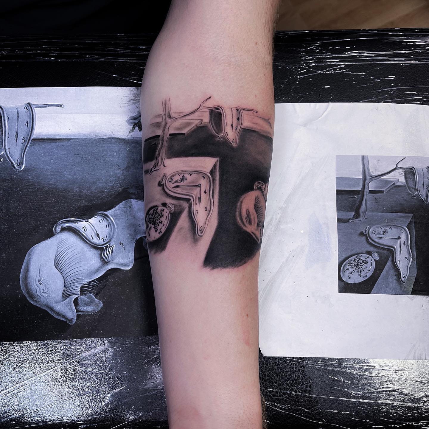 Melting clocks surrealism tattoo on the forearm by Joe Beasley