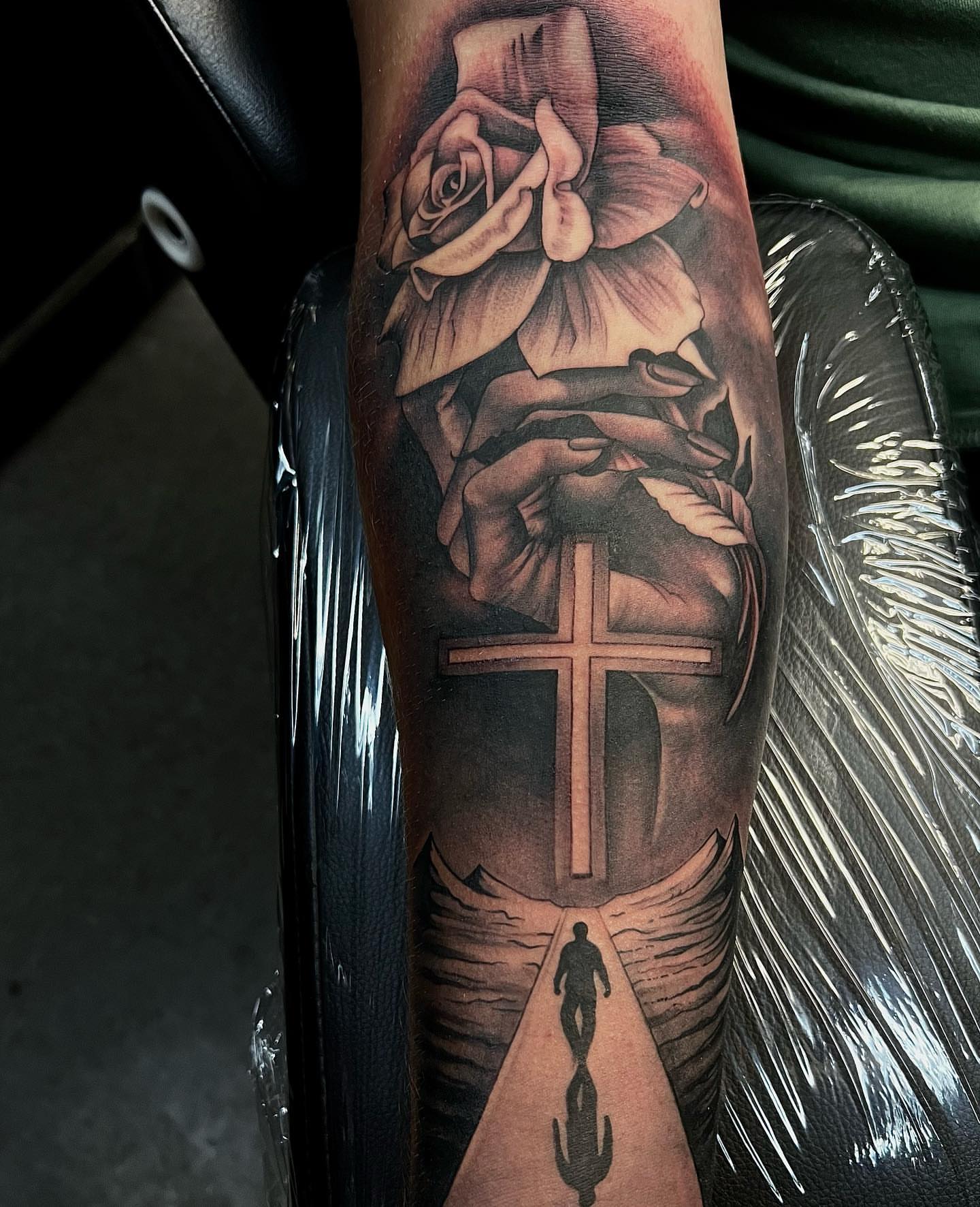 Cross and rose realism tattoo on the forearm by Jayden A
