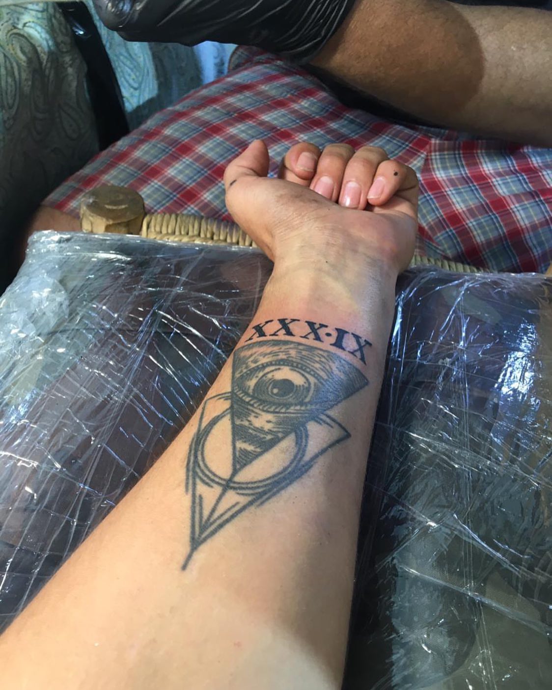 Eye and Roman numerals black and grey tattoo on the forearm by El Zepa