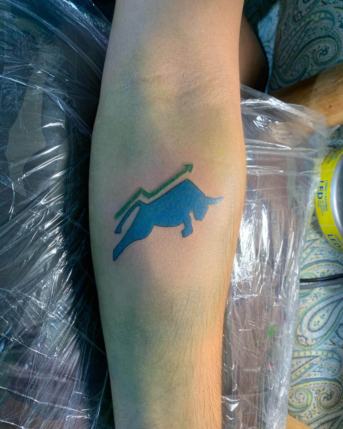 Bull and upward arrow geometric tattoo on the forearm by El Zepa