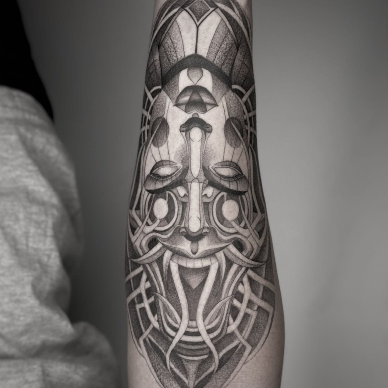Geometric mask geometric tattoo on the forearm by Paige Jean