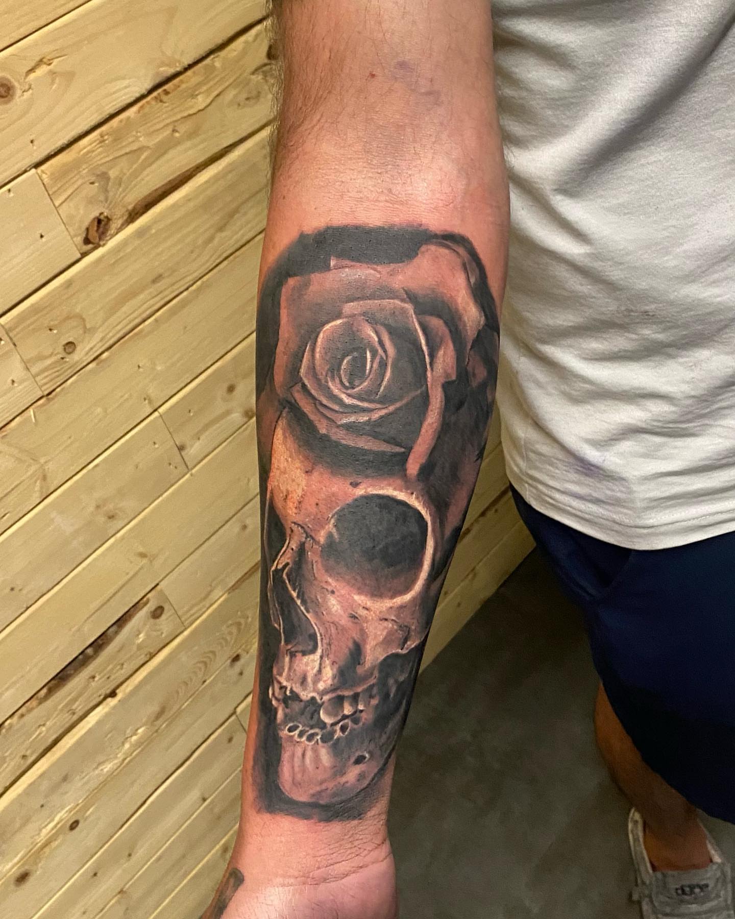 Skull and rose realism tattoo on the forearm by Zach Ashton