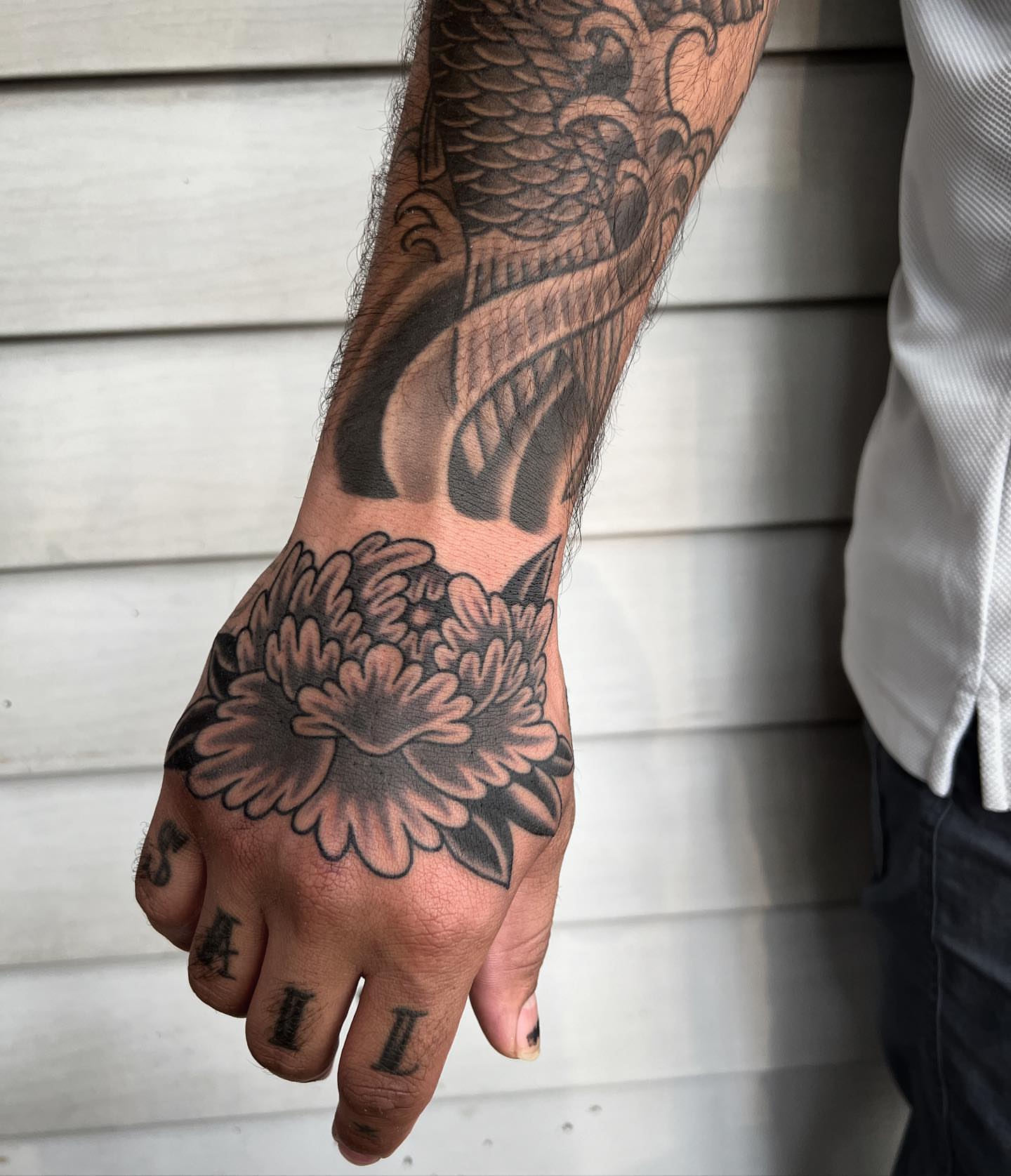 Chrysanthemum black and grey tattoo on the hand by Daniel Mesen