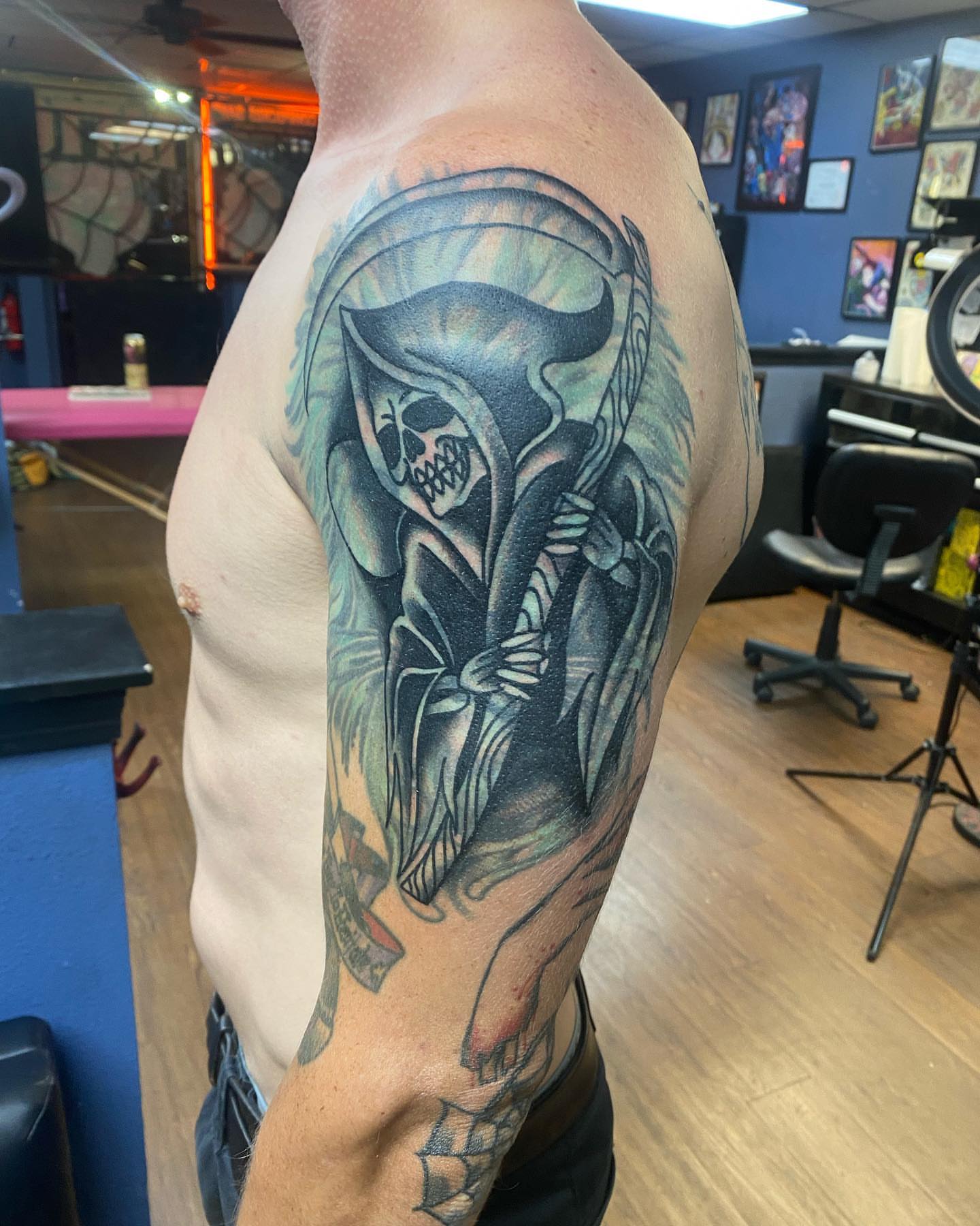 Reaper black and grey tattoo on the upper arm by Payton Prentice