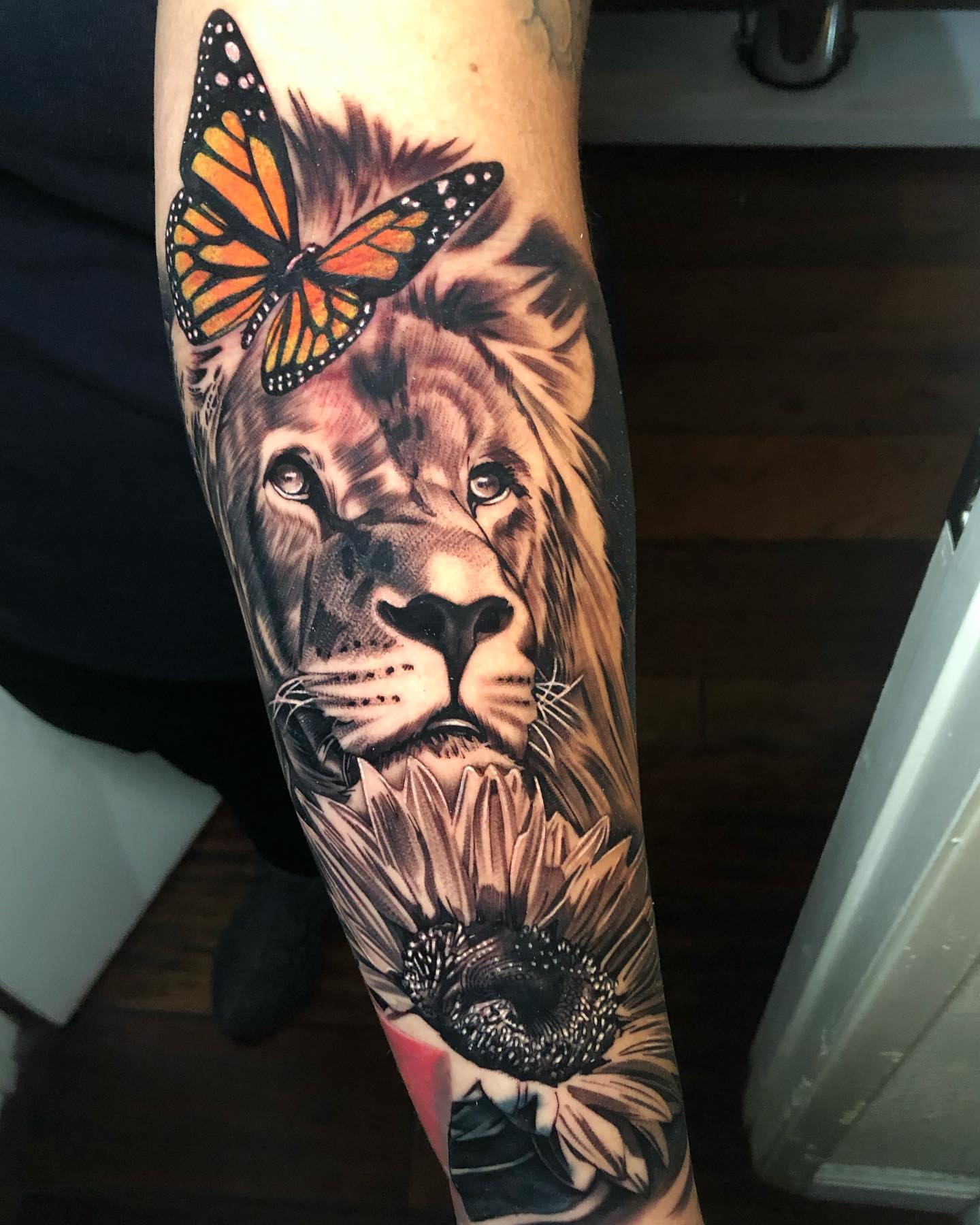 Lion and sunflower realism tattoo on the forearm by Michael Martinez