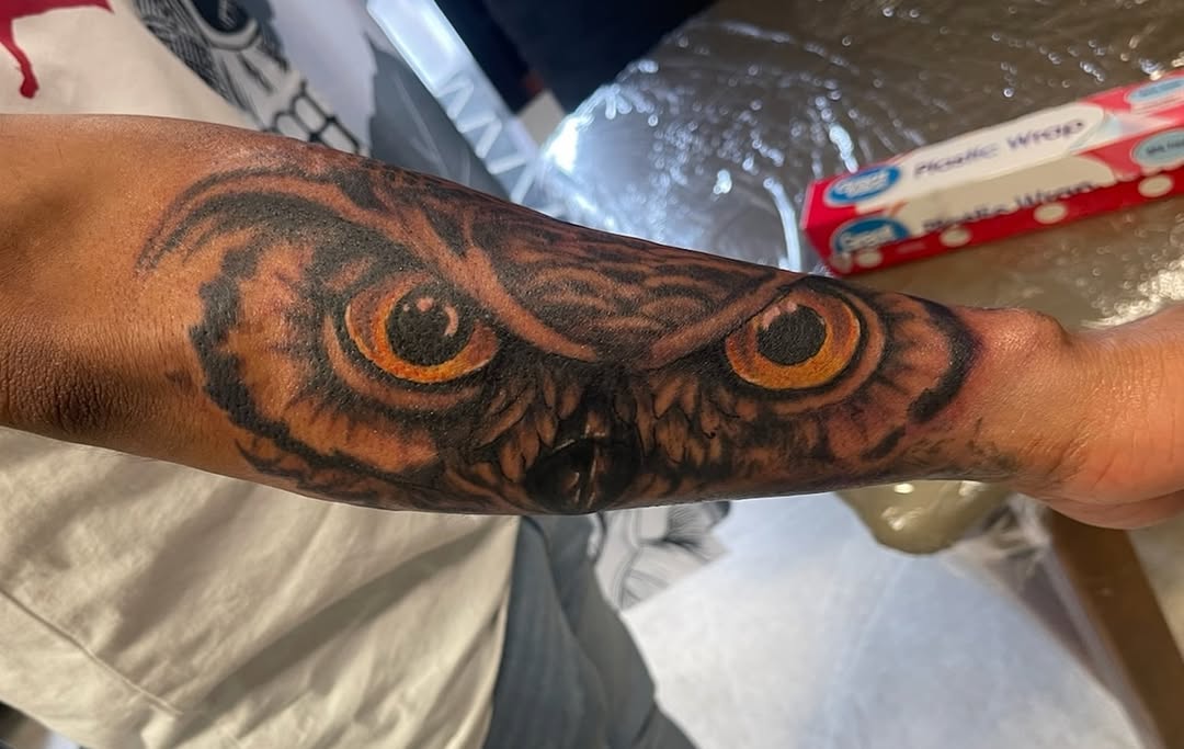 Owl eyes realism tattoo on the forearm by Russell Lucas