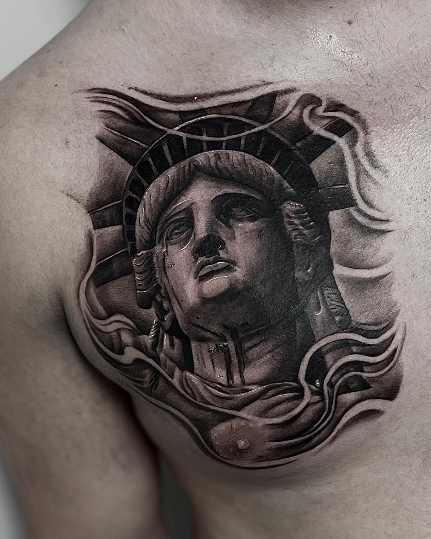 Statue of liberty realism tattoo on the chest by Aaron Watson