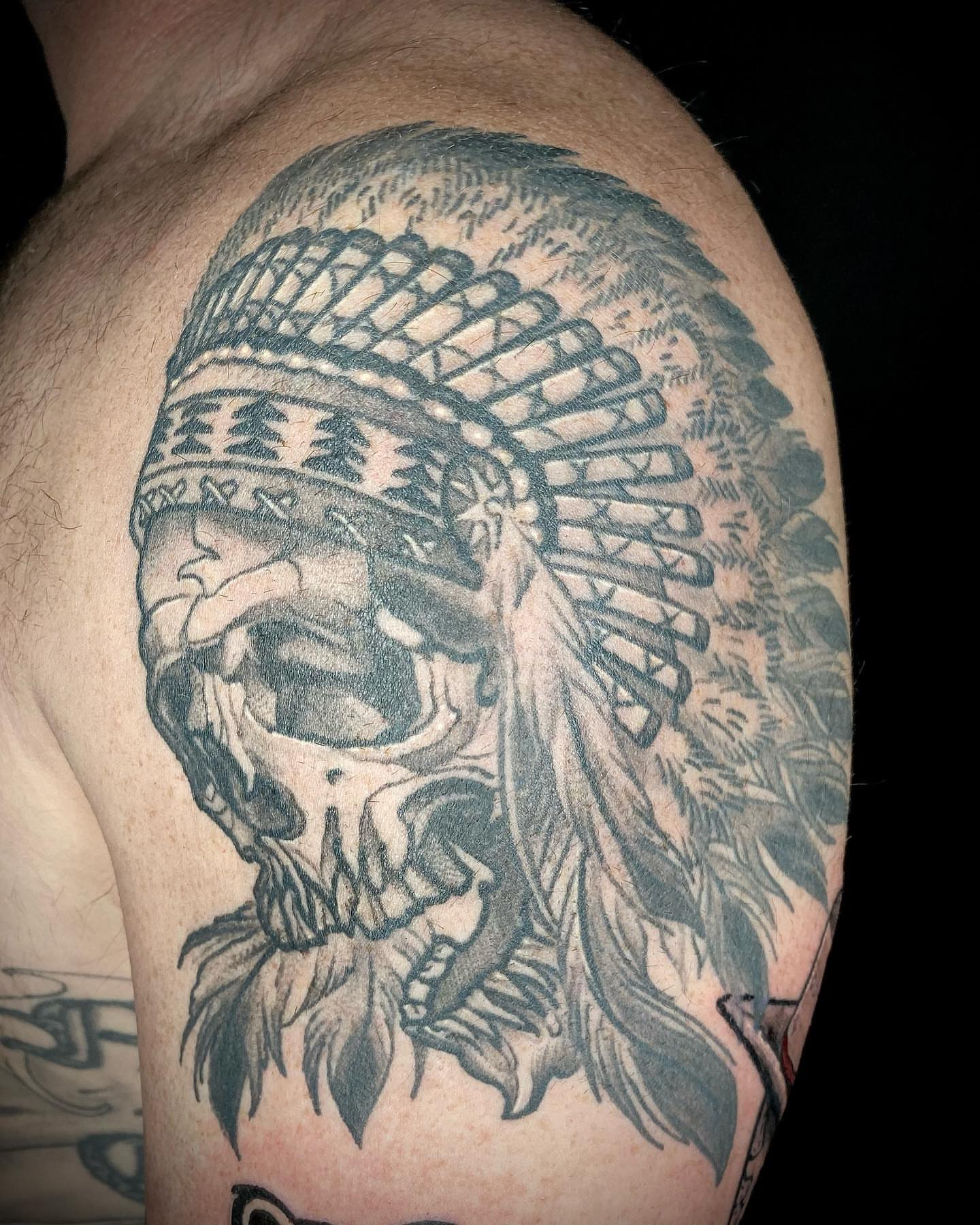 Skull wearing headdress realism tattoo on the shoulder by Josh St.germain
