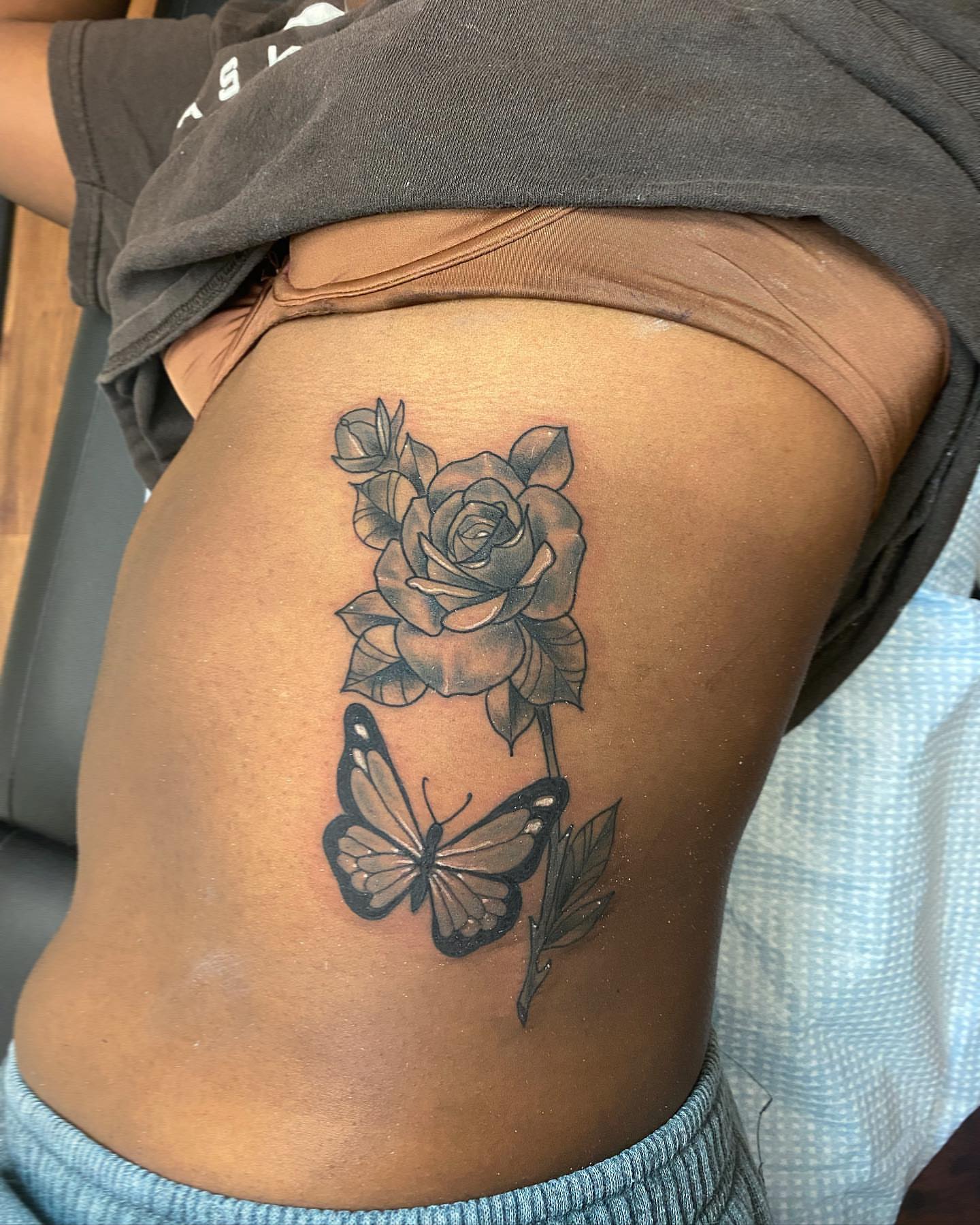 Rose and butterfly black and grey tattoo on the thigh by Diana Kunz