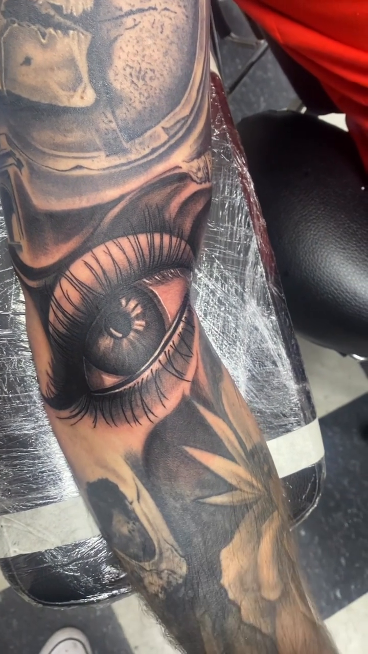 Eye with skull and foliage realism tattoo by Andrew Wine🍷Tattoo