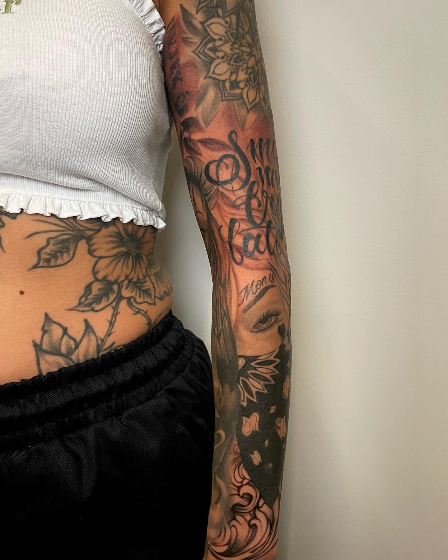 Floral and script American traditional tattoo on the upper arm by Sam Oakes