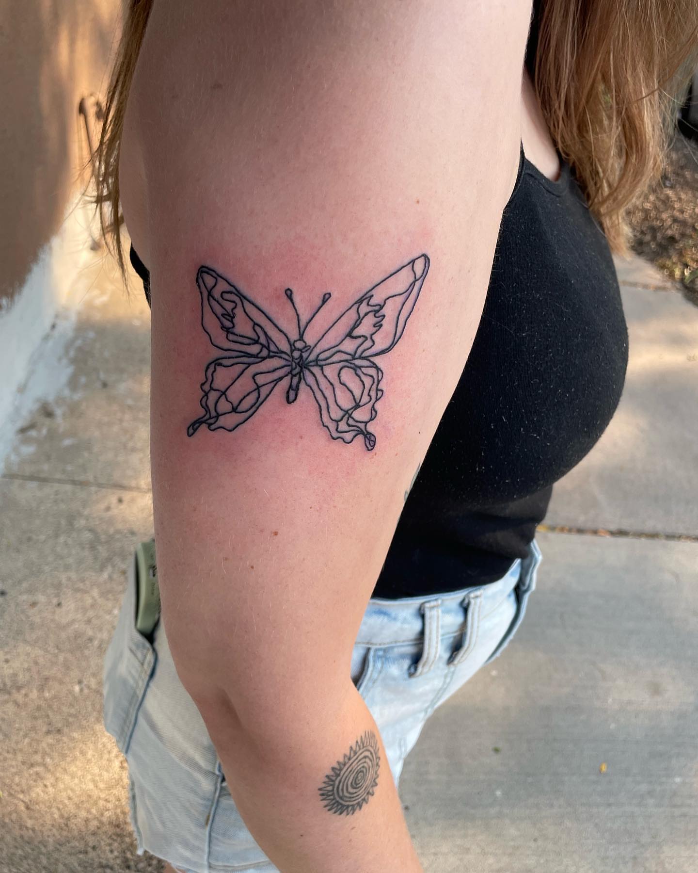 Butterfly fine line tattoo on the thigh by Anna sabrowsky