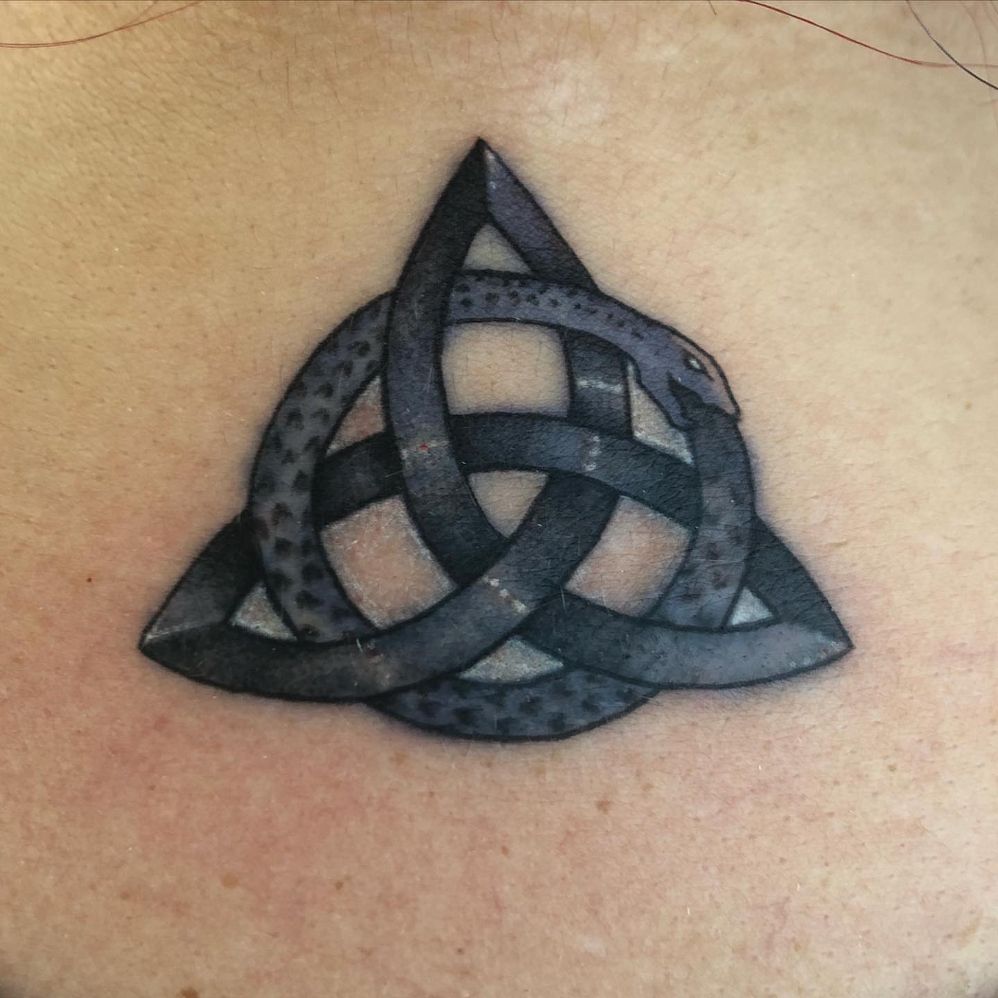 Trinity knot geometric tattoo on the chest by Marta La Jirafa