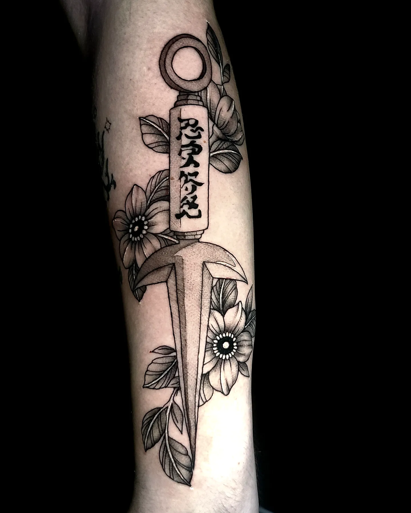 Katana and flowers black and grey tattoo on the forearm by Sydney Paige, Mentor, Ohio