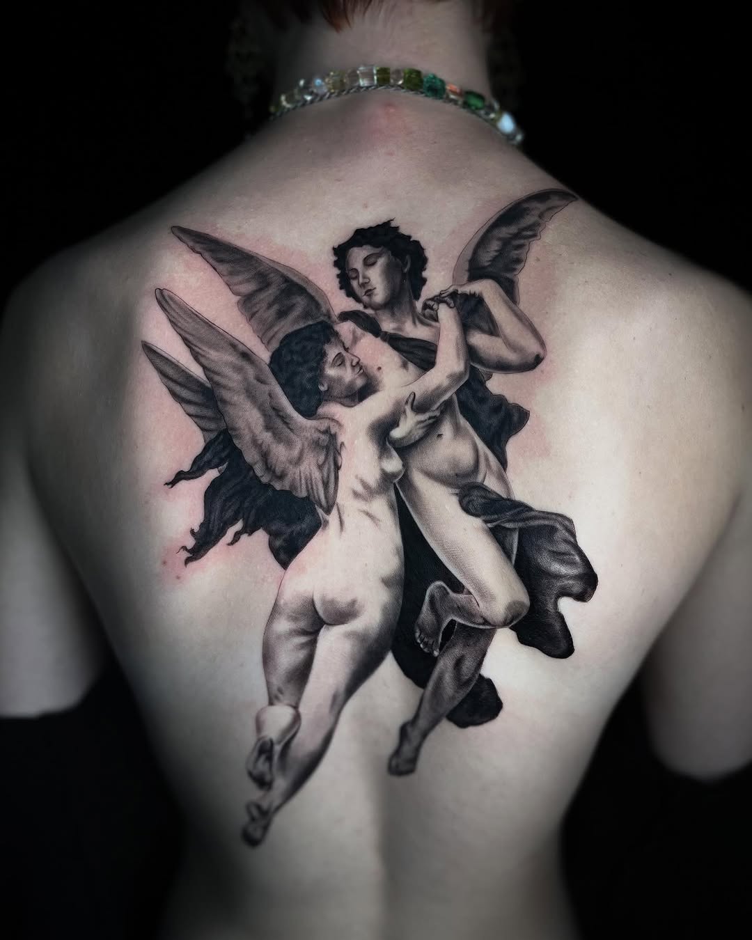 Two cherubs embracing realism tattoo on the back by Demi DiMartino