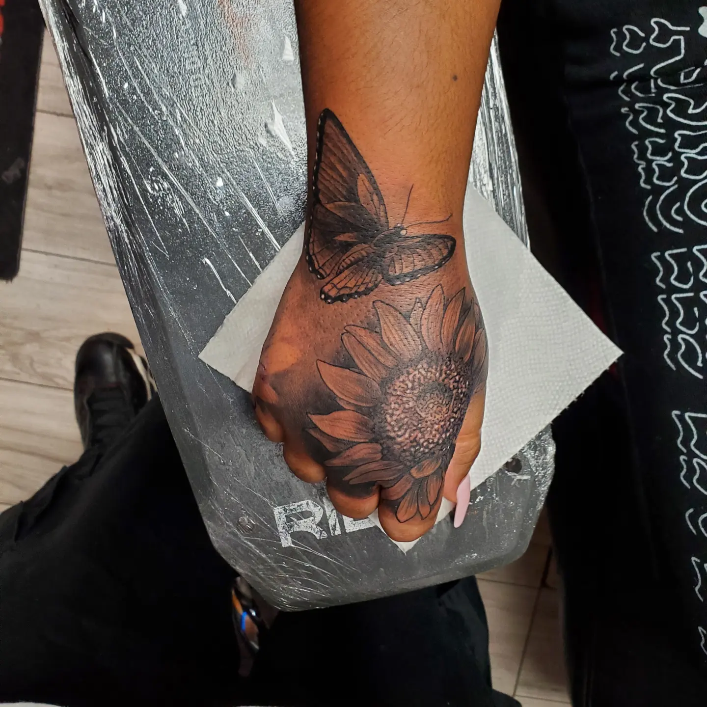 Sunflower and butterfly realism tattoo on the hand by Chris TL Jones