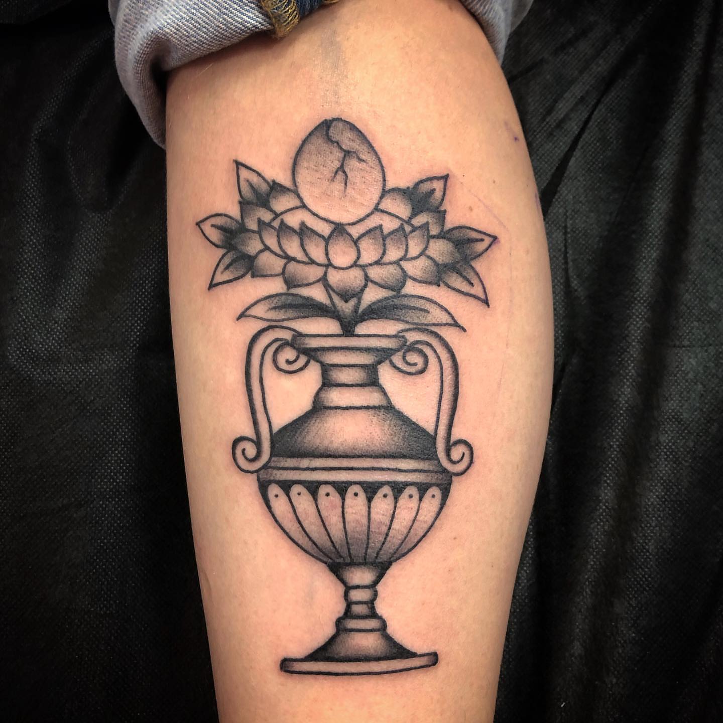 Lotus flower in vase black and grey tattoo on the forearm by Paul Trimble