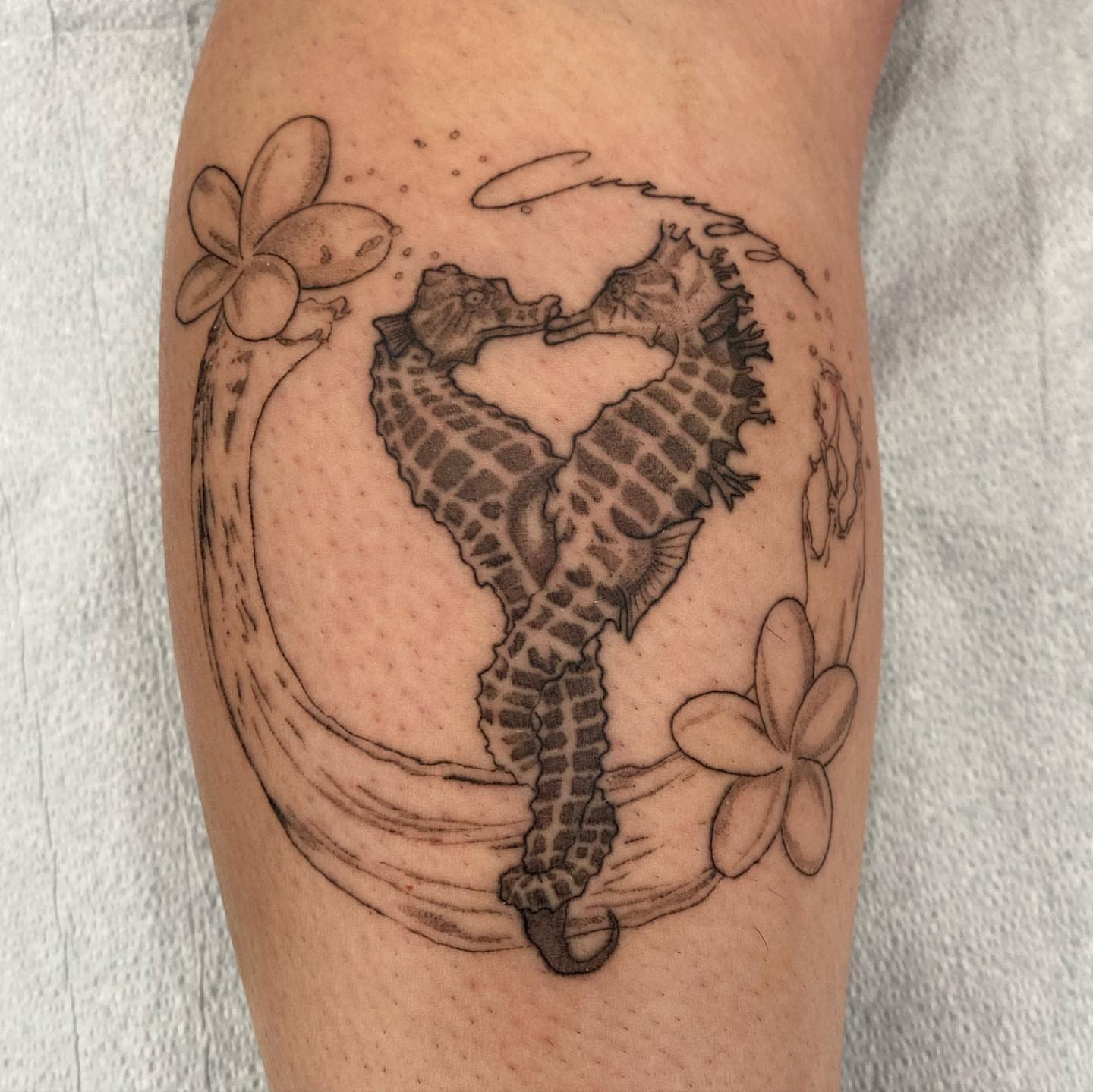 Seahorse and wave black and grey tattoo on the forearm by Riki
