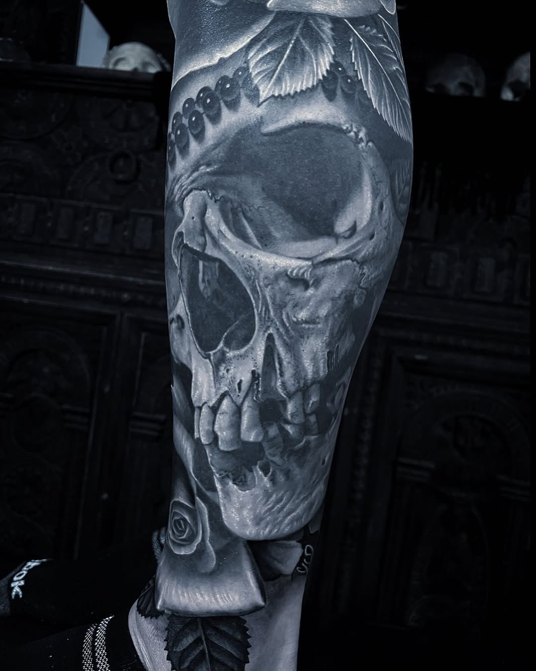 Skull with roses and leaves dark art tattoo on the forearm by Gabriel Londis